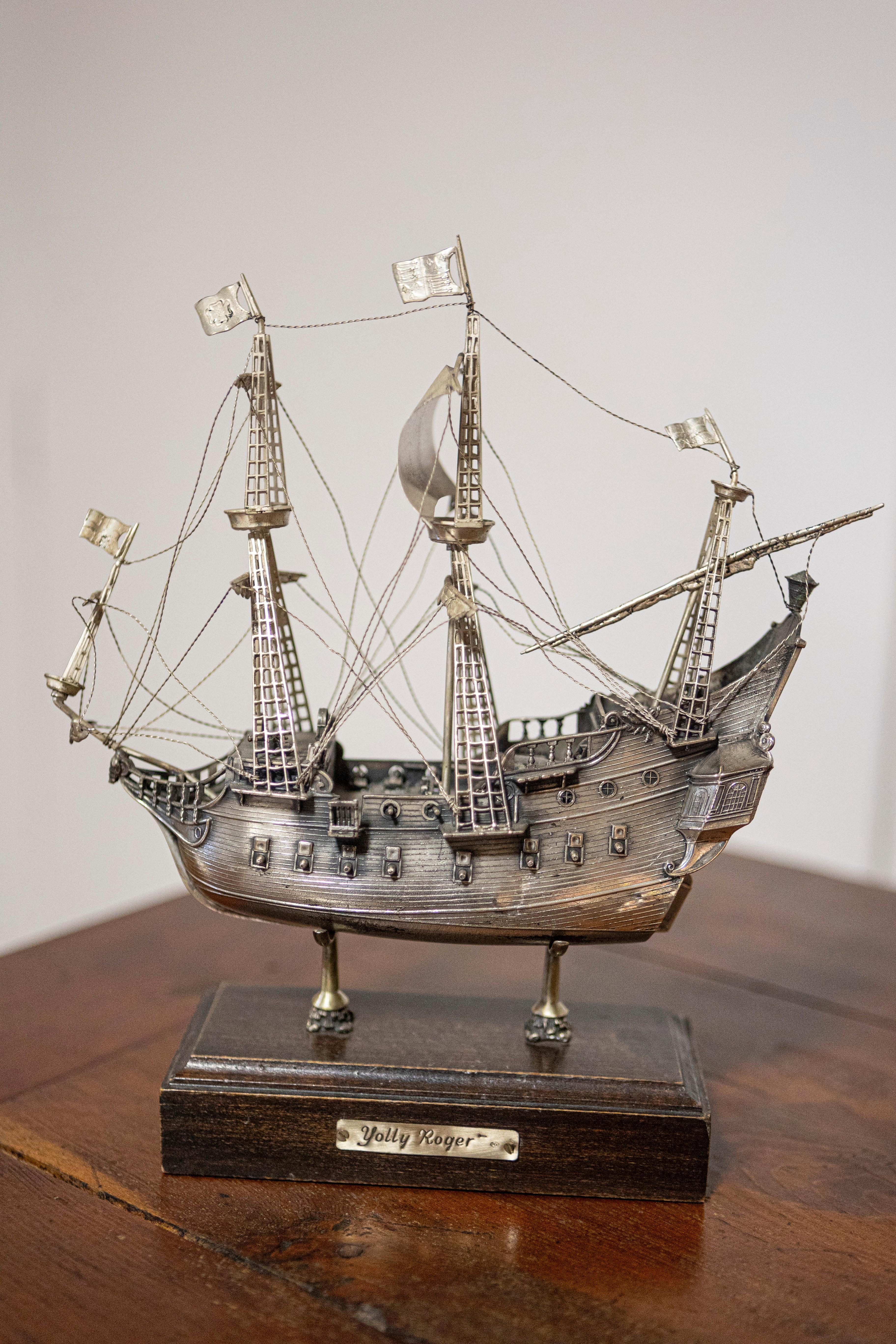 Modello di nave pirata Jolly Roger veneziana del XX secolo, realizzata in lega di peltro e montata su una base di legno. Questo affascinante modello di nave pirata veneziana Jolly Roger del XX secolo è una testimonianza di artigianato meticoloso e