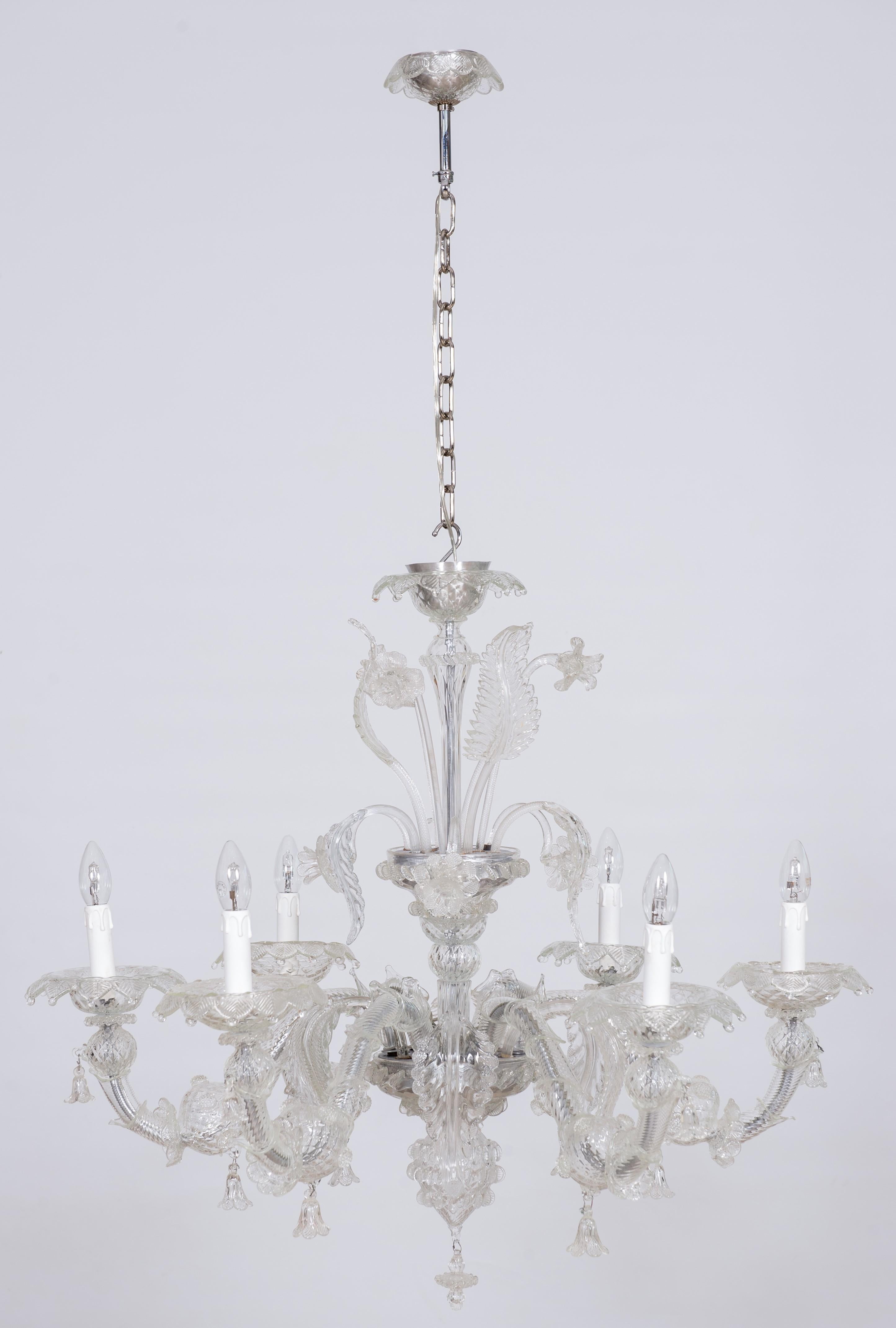 Venetian Rezzonico chandelier in transparent Murano glass with 6 lights, Italy.
This marvellous chandelier is an outstanding example of Italian glass art and passion for details. Made of transparent Murano glass, it has six arms decorated with wavy