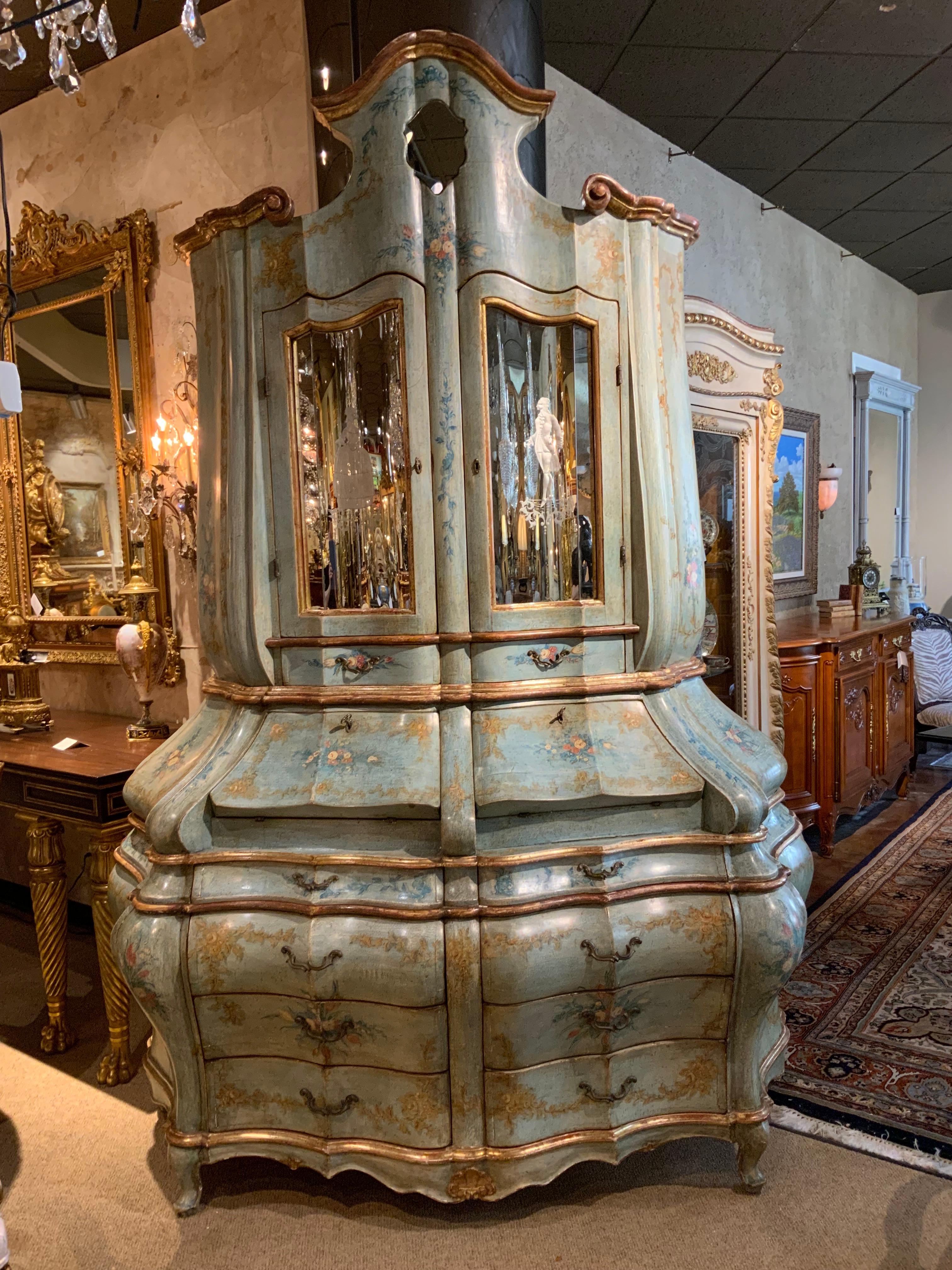 This fine quality Venetian secretary is beautifully carved and finely
Painted in pale teal and rose hues.  The bottom is carved in a bombe
Shape and has four drawers that slide easily. The upper section has 
Two doors with mirrors inset and that are