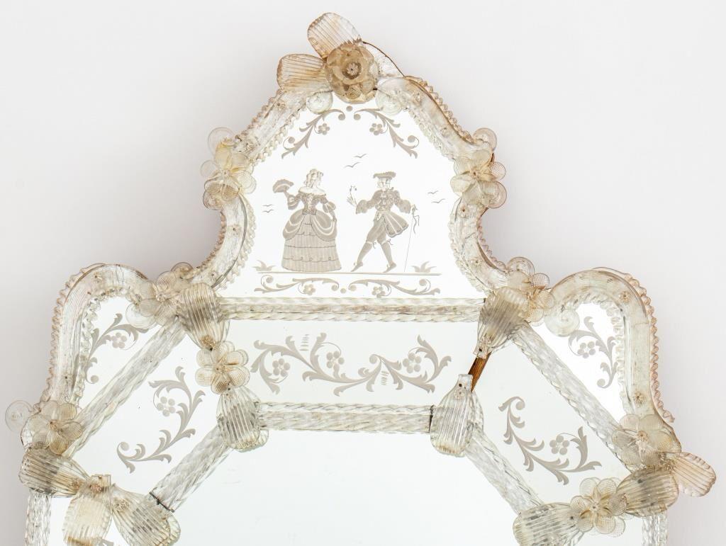 Venetian Rococo style blown and engraved glass mirror, of shaped elongated octagonal form, the top centering an engraved mirror plate depicting a Venetian lady and gentleman flanked by blown and engraved glass volutes, above an elongated octagonal