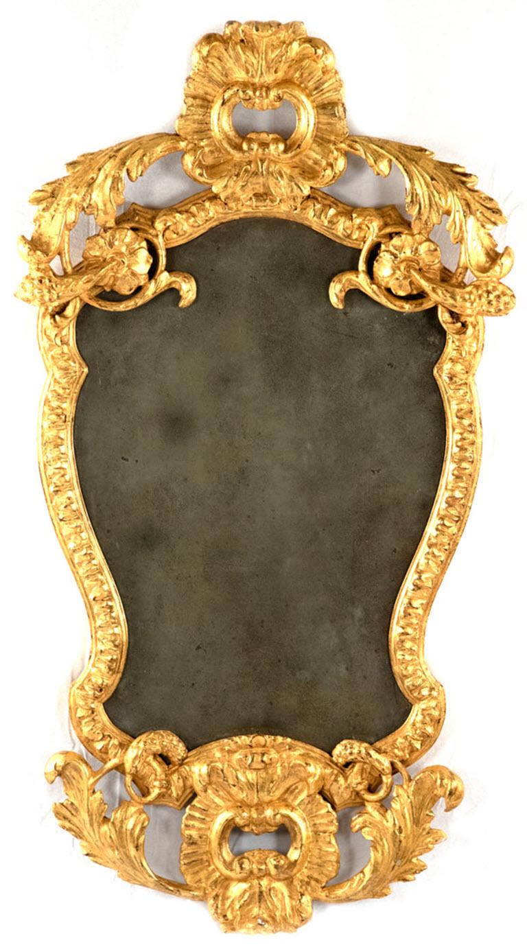 An elaborately carved, gessoed, and gilt mirror with diamond dust mirror dating to the first half of the nineteenth century.