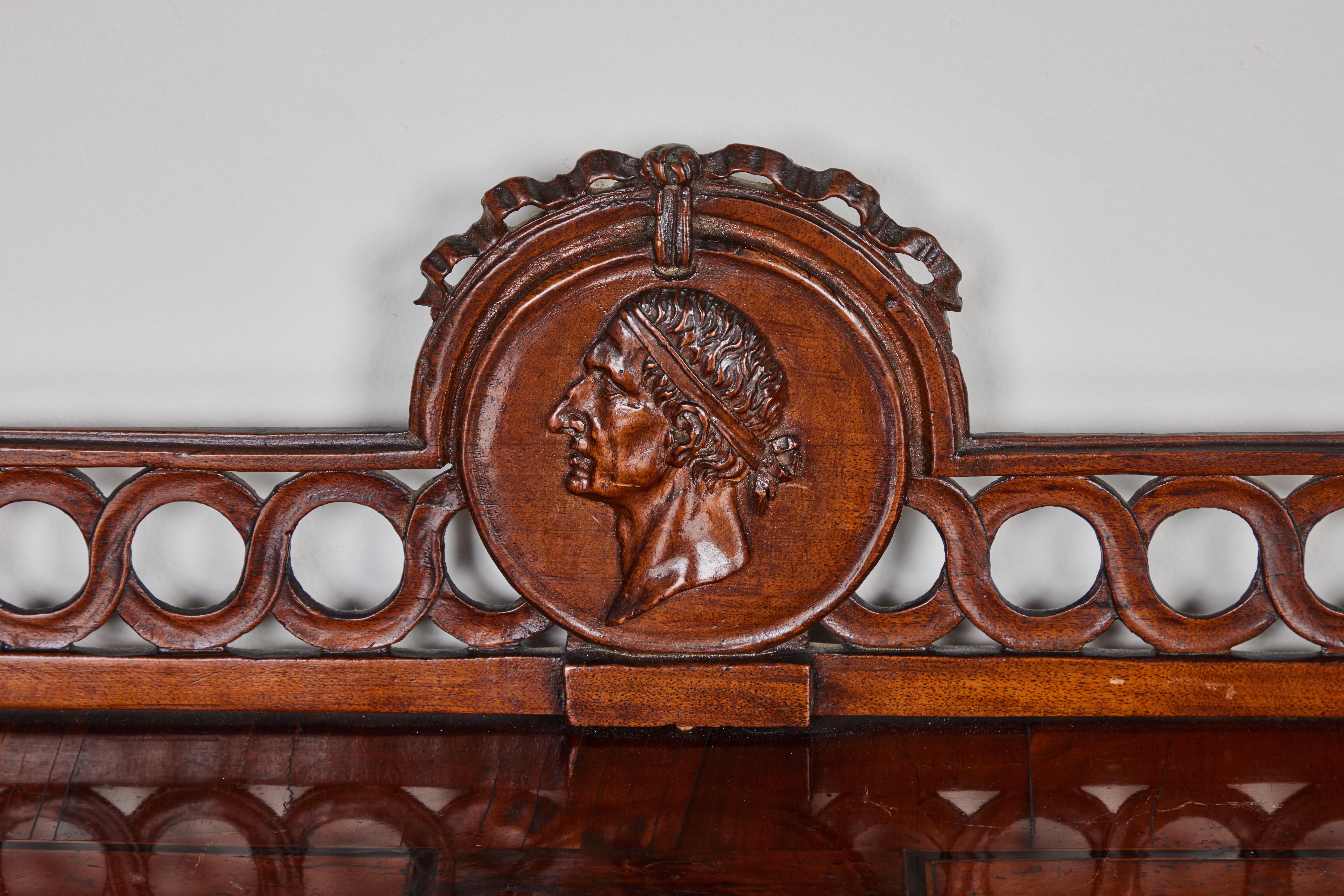 A Venetian, hand carved roll top desk in burled walnut veneer. Fitted interior with pull out, sliding writing area with inset red leather. A carved wooden gallery with a Neoclassical profile medallion in center tops this beautiful desk. Original