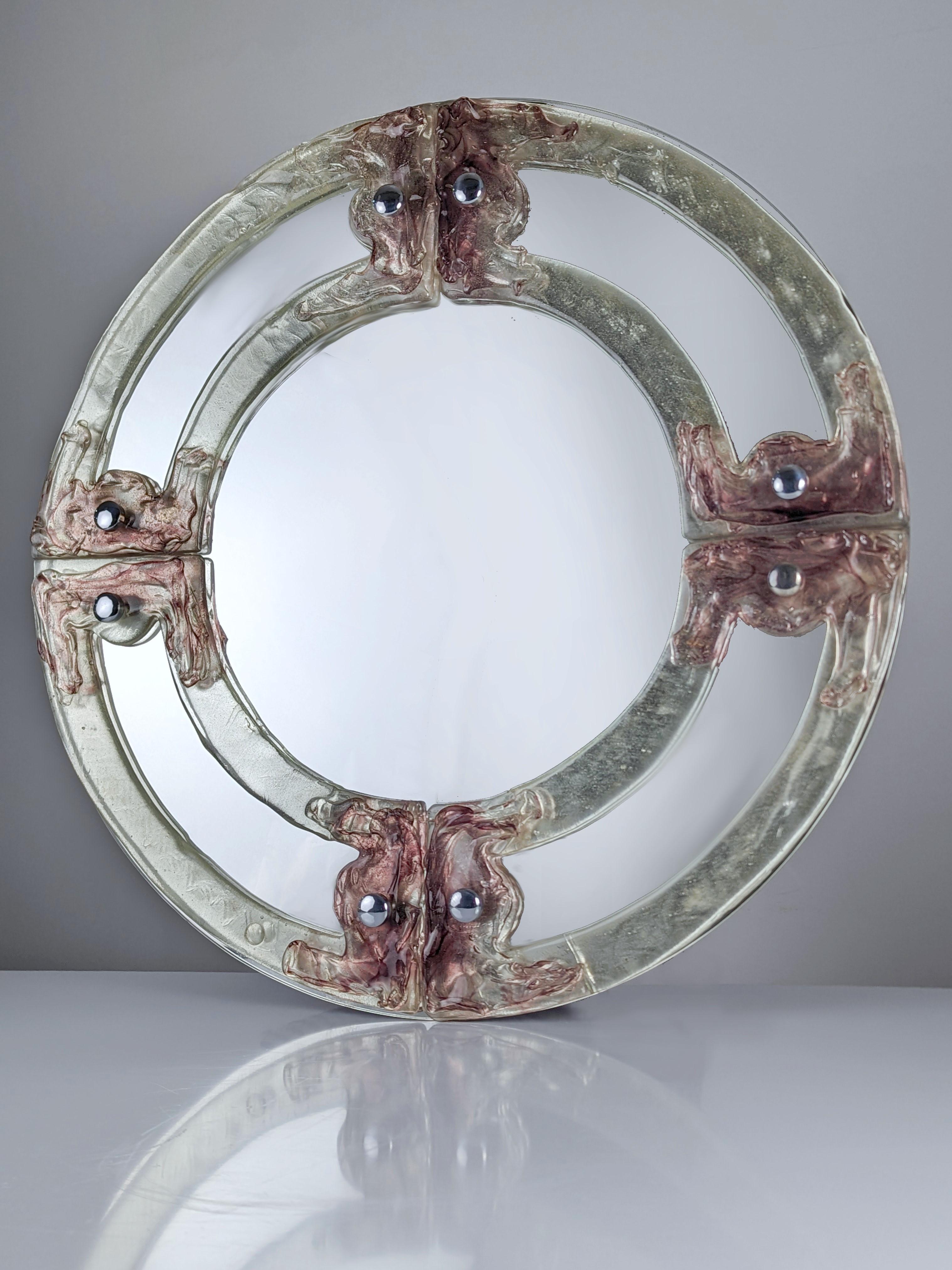 Spectacular round Murano glass mirror in shades of pink and purple, an authentic treasure from the 1960s. Its exquisite Murano glass reflects the rich artisanal heritage of Venice, with a design that captures the essence of the golden age of Italian