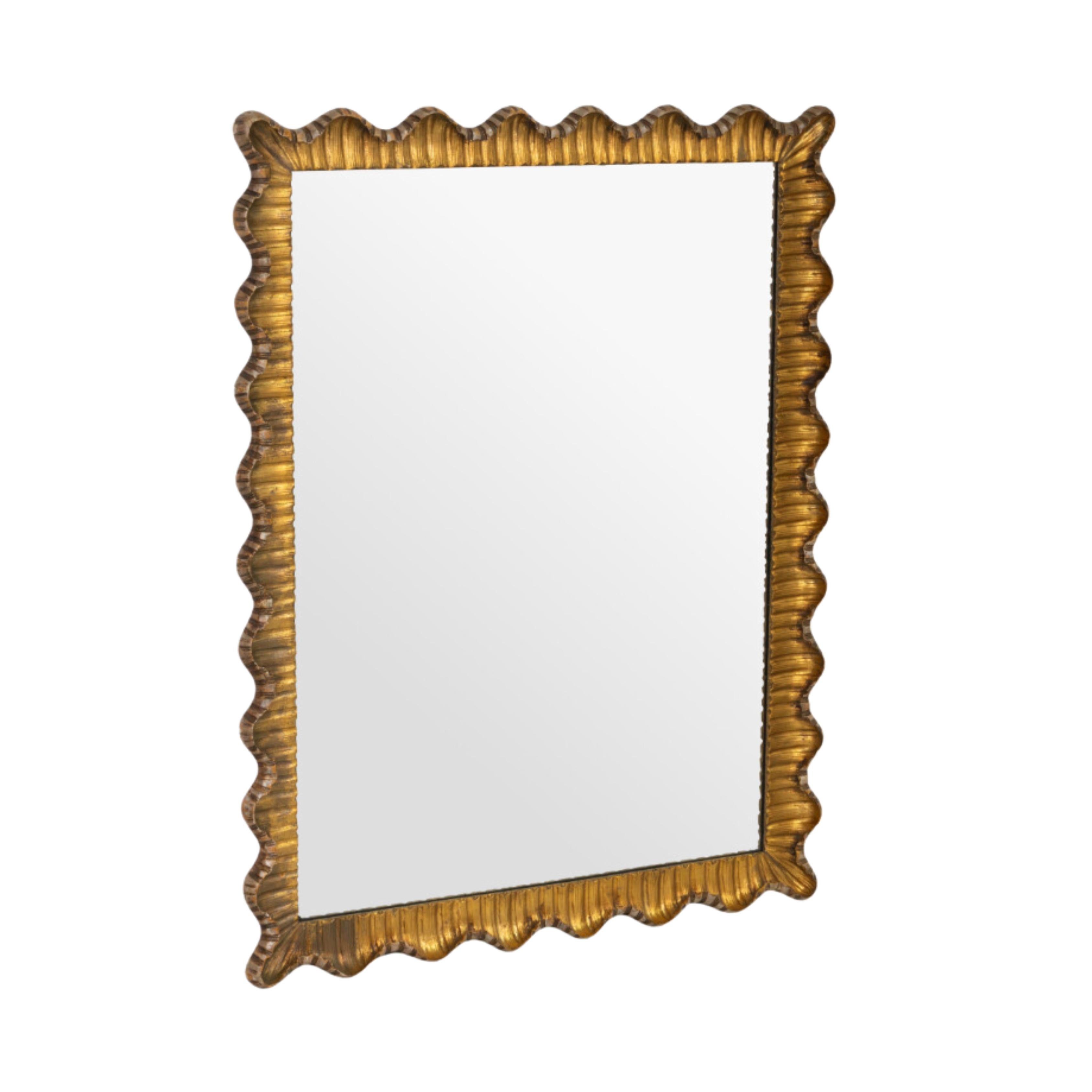 Carved and scalloped Italian Regency-style giltwood mirror. The frame is crafted by carving wood, applying plaster or gesso, and finishing with gold leaf for an elegant, radiant look. It’s in excellent vintage condition, with minor nicks to the gold
