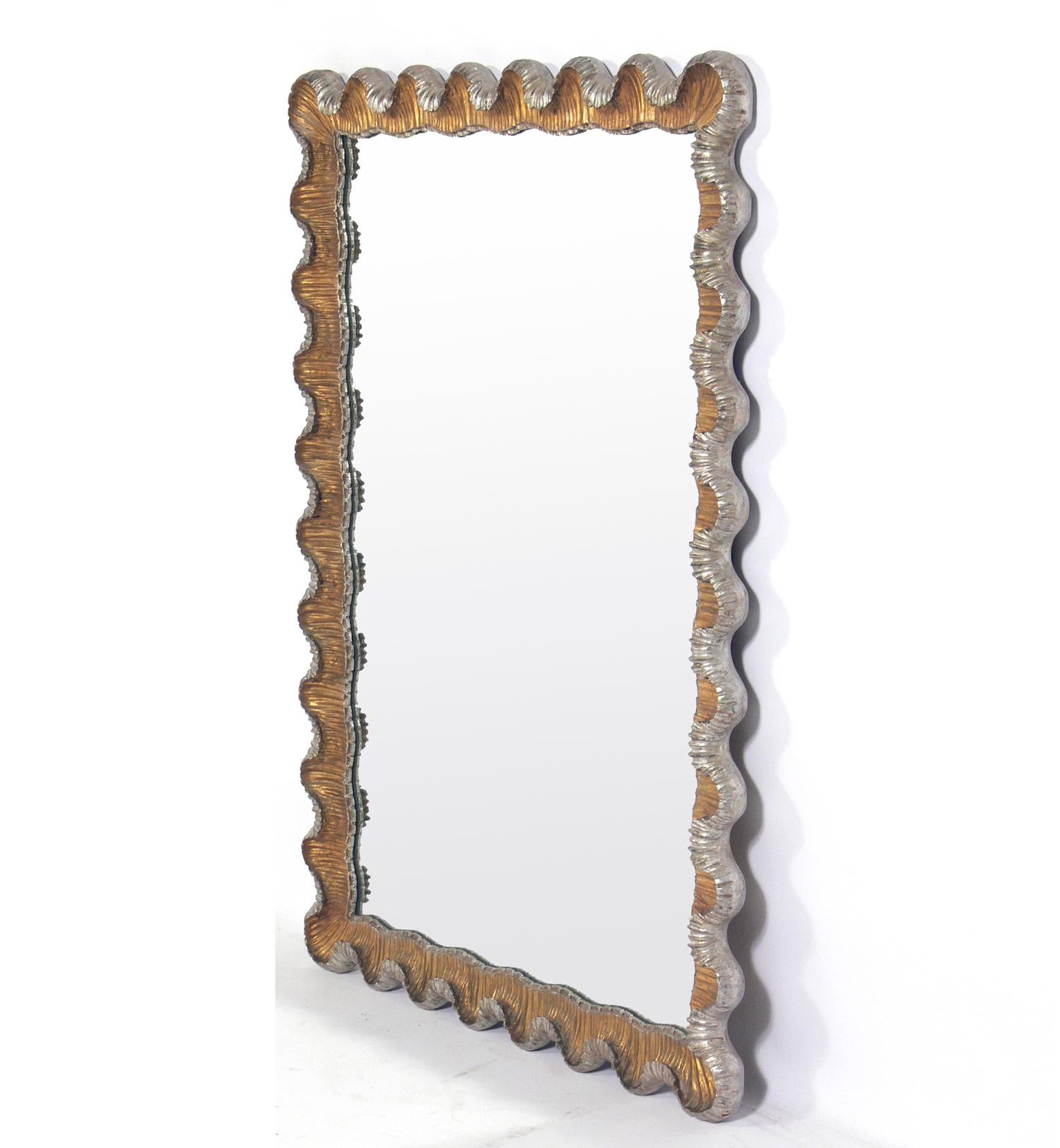 Venetian scalloped mirror, Italy, circa 1950s. Gold leaf on the front side and silver leafed on the outer sides and back of the frame. Undulating curves of hand carved and giltwood and gesso give this mirror it's elegant form. The original gilt