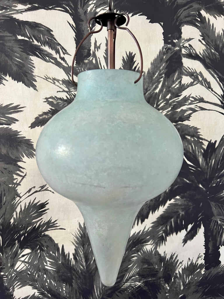Venetian blown glass pendant light with acid etched finish in aqua.  Scavo is a technique using high heat to create a weathered archeological finish to the glass. 
This Organic Modernist pendant evokes both a Moorish and Turkish Ottoman inspired