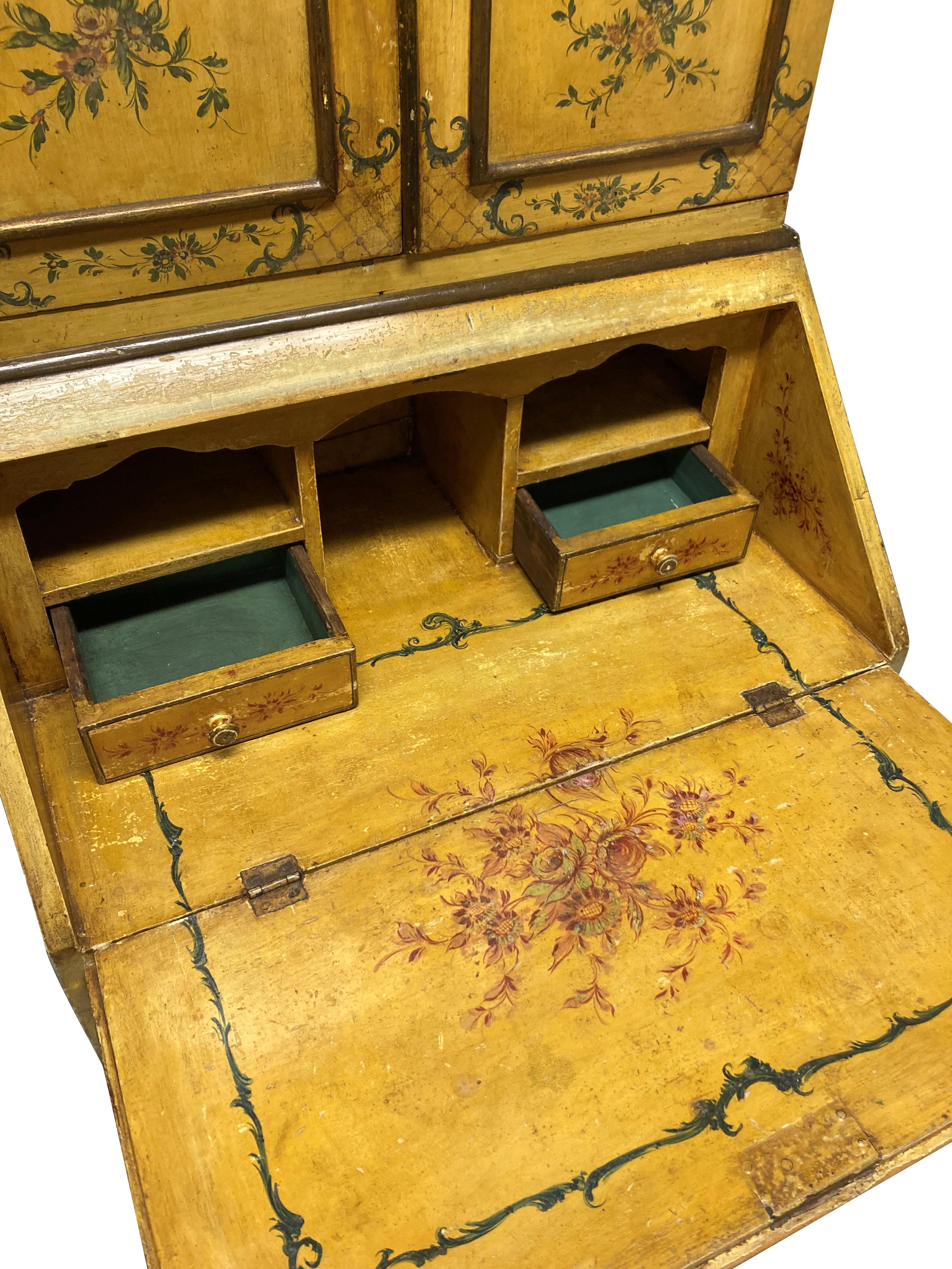 A late 19th Century Venetian secretaire cabinet in a striking yellow lacquer, with beautifully hand painted decoration throughout. With four drawers beneath the fall front desk and the upper cabinet with four shelves, painted aquamarine, with an