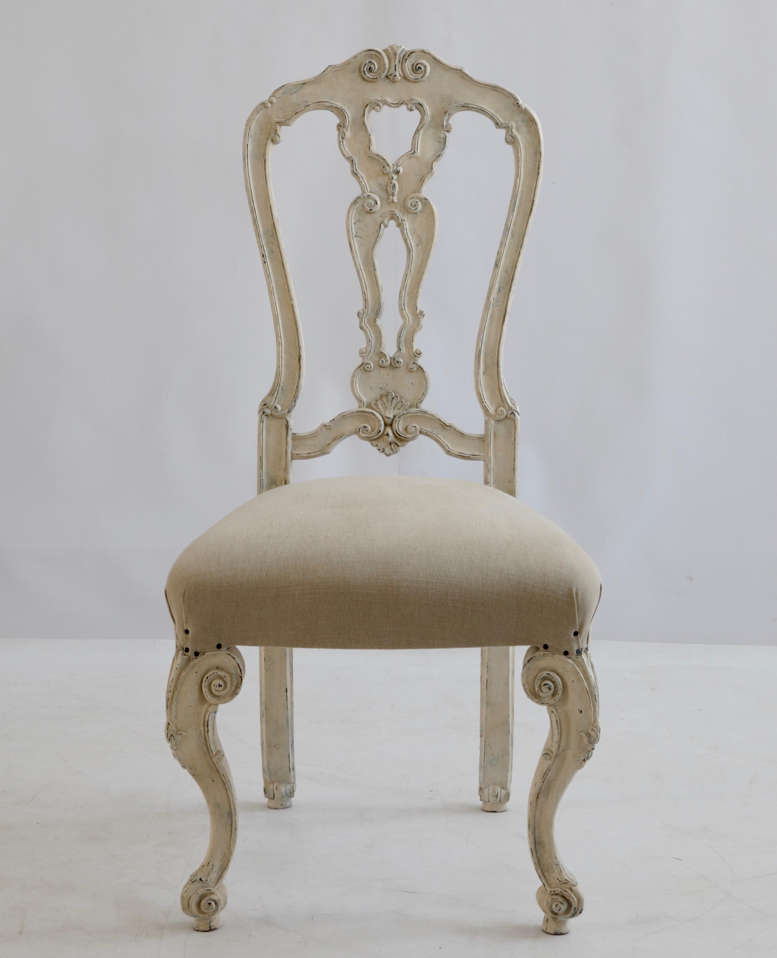 Ensemble de six chaises de salle à manger de style vénitien, sculptées à la main, avec de hauts dossiers et des proportions générales élégantes.
Les chaises sont finies dans une patine blanche Gesso peinte à la main et vieillie pour donner une