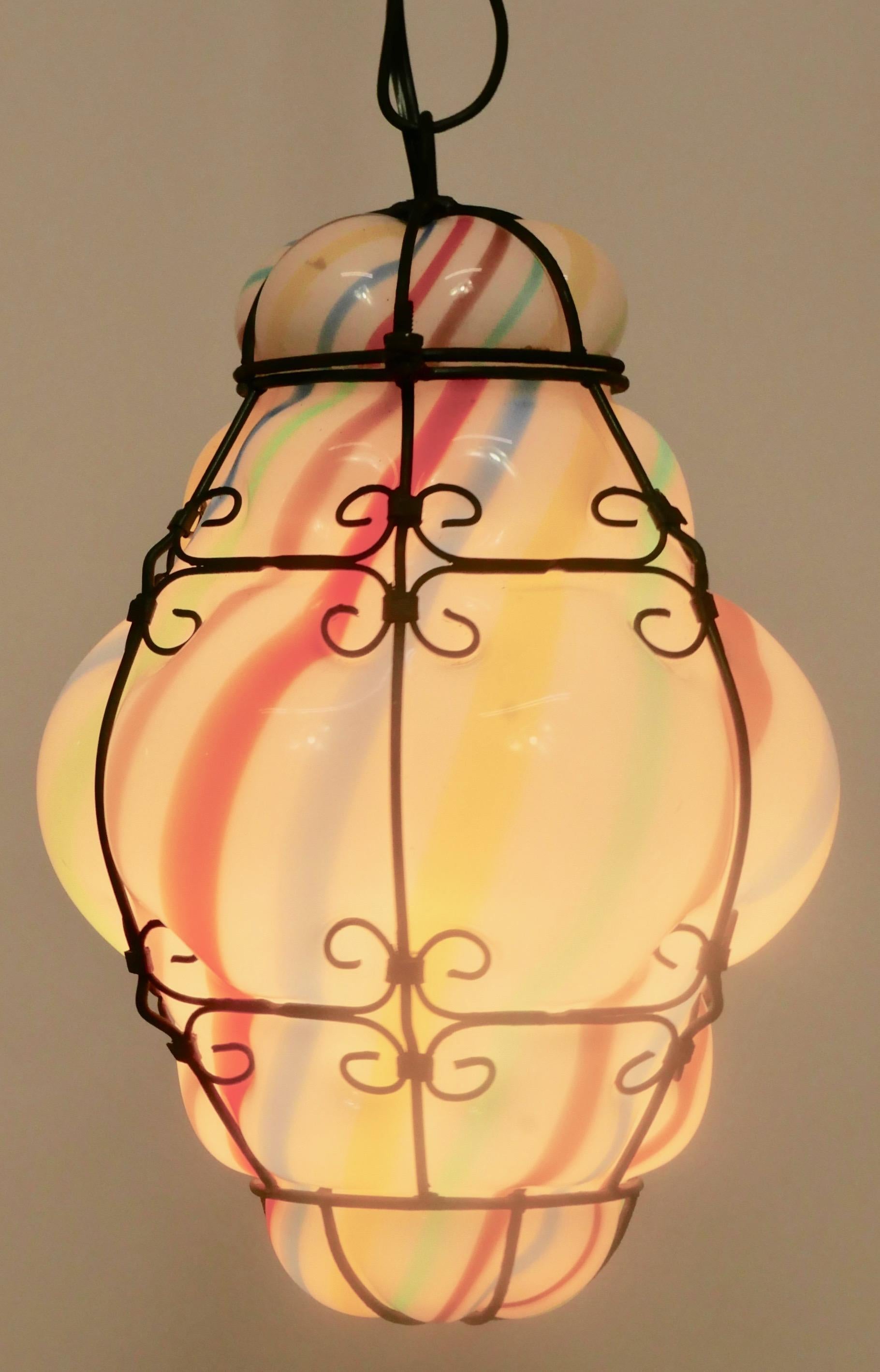Colorful hand blown and shaped Murano striped glass in a metal cage hanging pendant. Hanging metal chain can be adjusted.
Venice, Italy
Early 20th century.