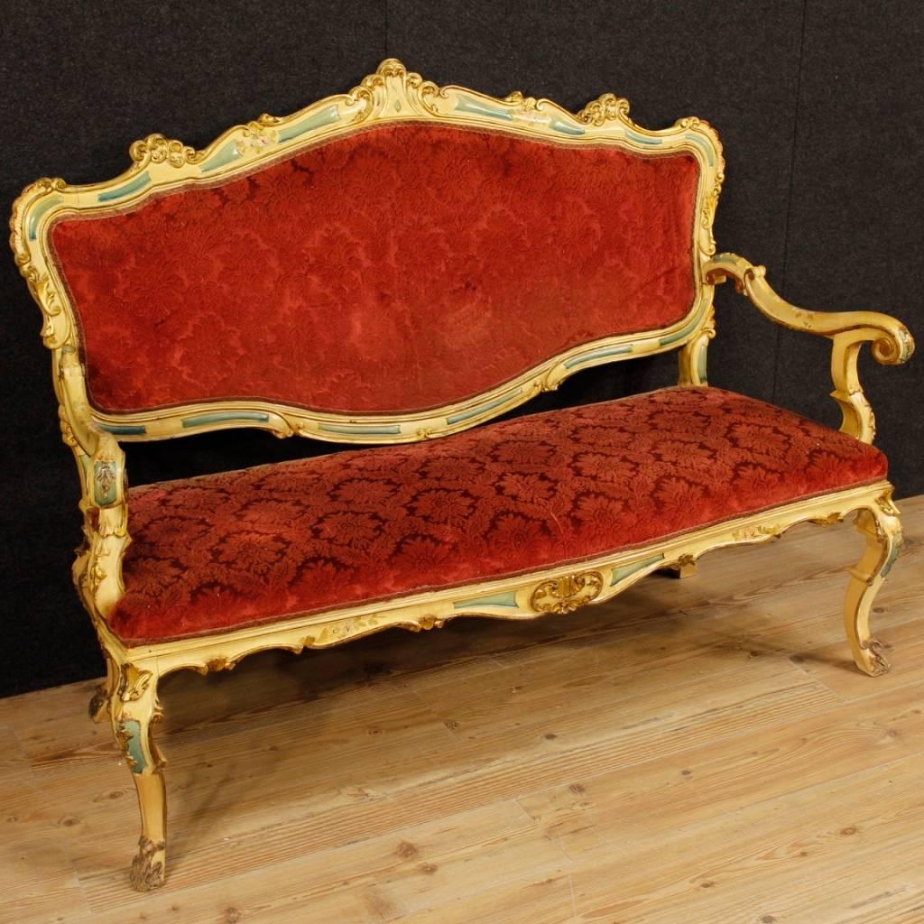 Venetian sofa from 20th century. Furniture in carved, lacquered and gilded wood. of great decoration. Sofa covered with red floral fabric in good condition. Comfortable seat with padding in good condition. Measure: Height to seat 46 cm. Sofa that is