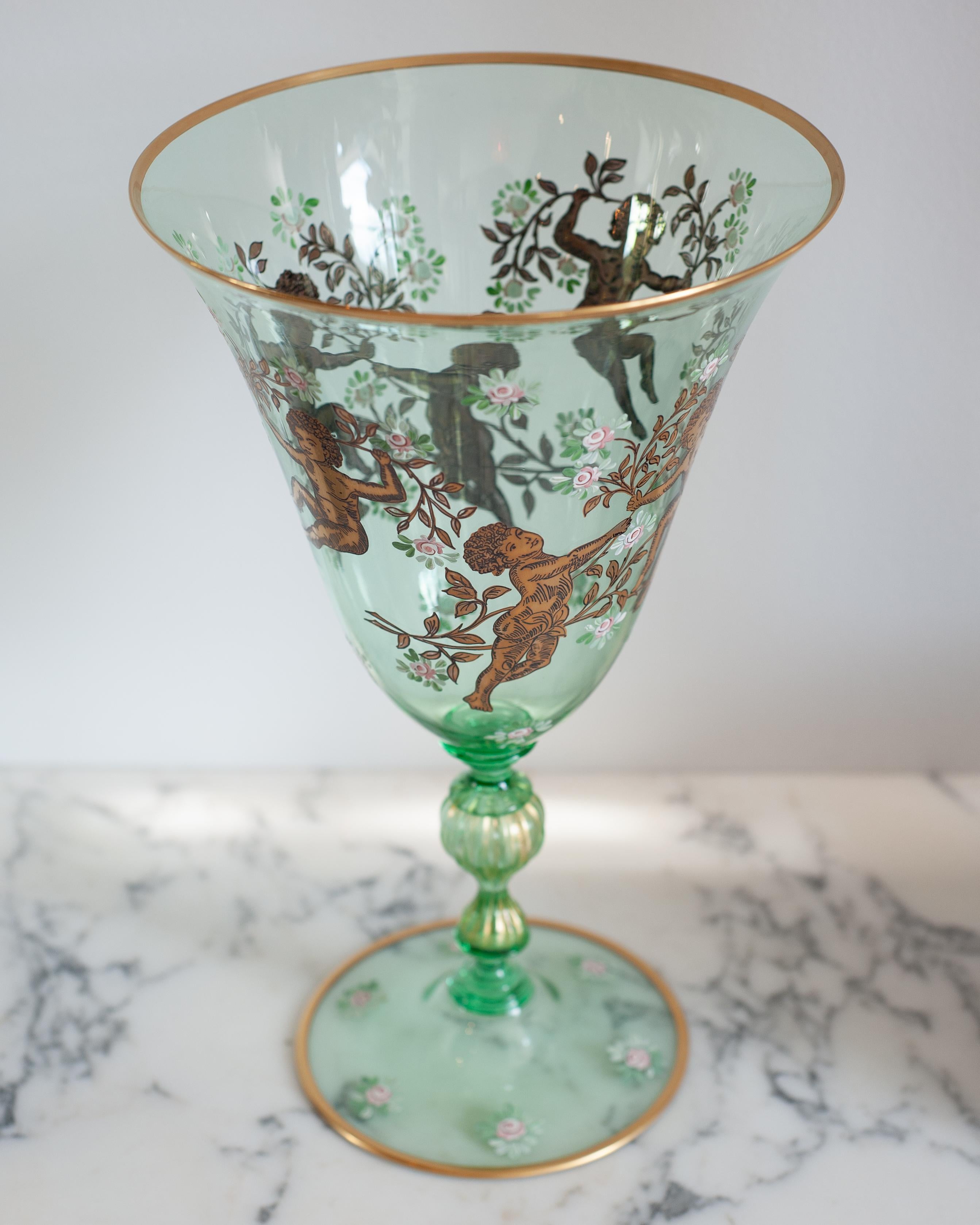 Apportez une touche d'élégance vénitienne dans votre maison avec ce vase Murano vert printanier fantaisiste, orné de feuilles d'or complexes. Décoré d'angelots et de motifs floraux, ce vase est une version moderne du design classique, nouvellement
