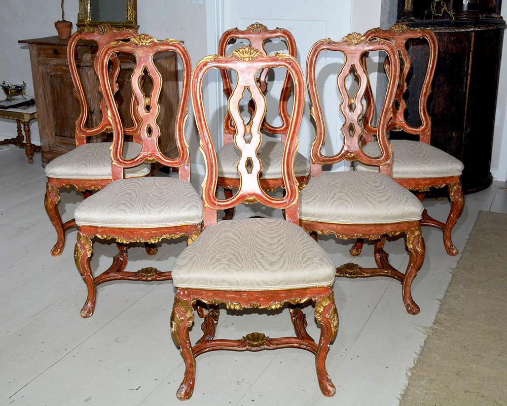 Very special set of 6 Italian Baroque or Swedish Rococo style dining side chairs featuring tall shapely backs, stretcher base, Queen Anne style legs, solid wood construction. Hand painted red and gilded with a distressed finish that accentuates the