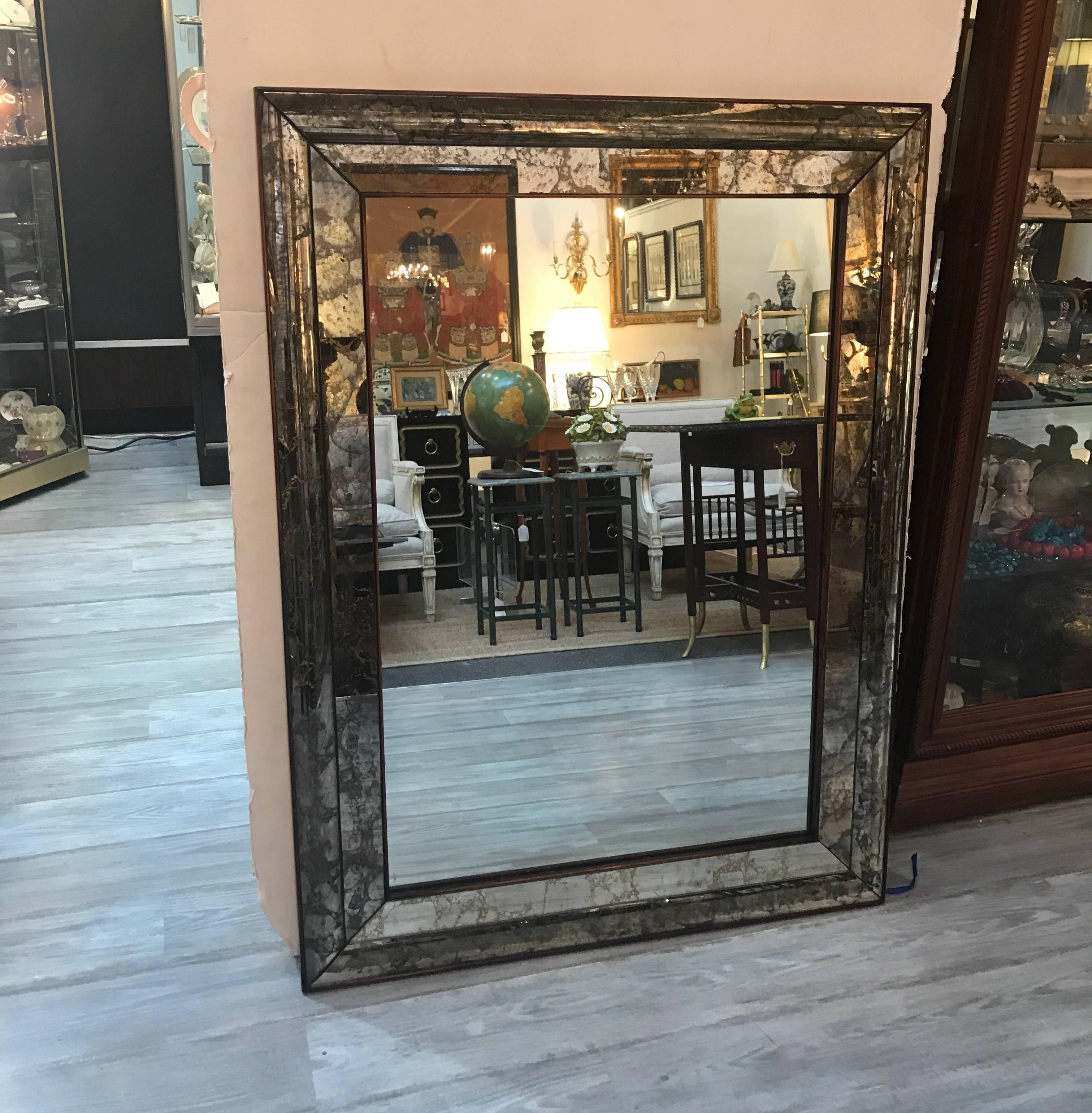 Sleek veined mirror framed wall mirror from circa 1950. The double layered frame with all over veining surrounds the large clear looking glass. The outer frame with a thin mahogany border. This mirror can he hung in either direction.
