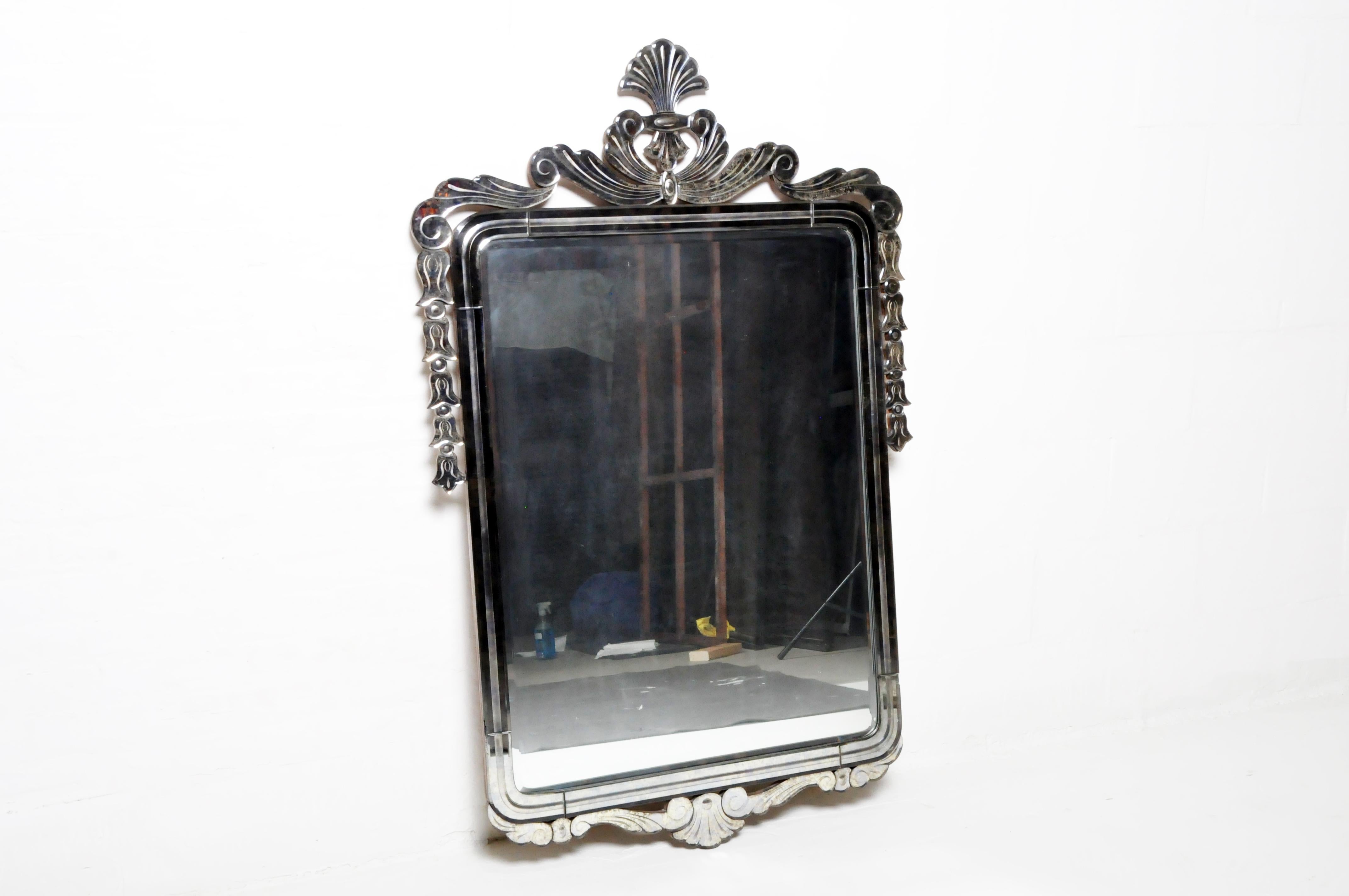 This Venetian style mirror is from Italy and was made from glass and metal, c. 20th century. This Venetian mirror is made form cut glass shards arranged in a simple and elegant Art Deco design. The frame is solid wood. The piece is contemporary and