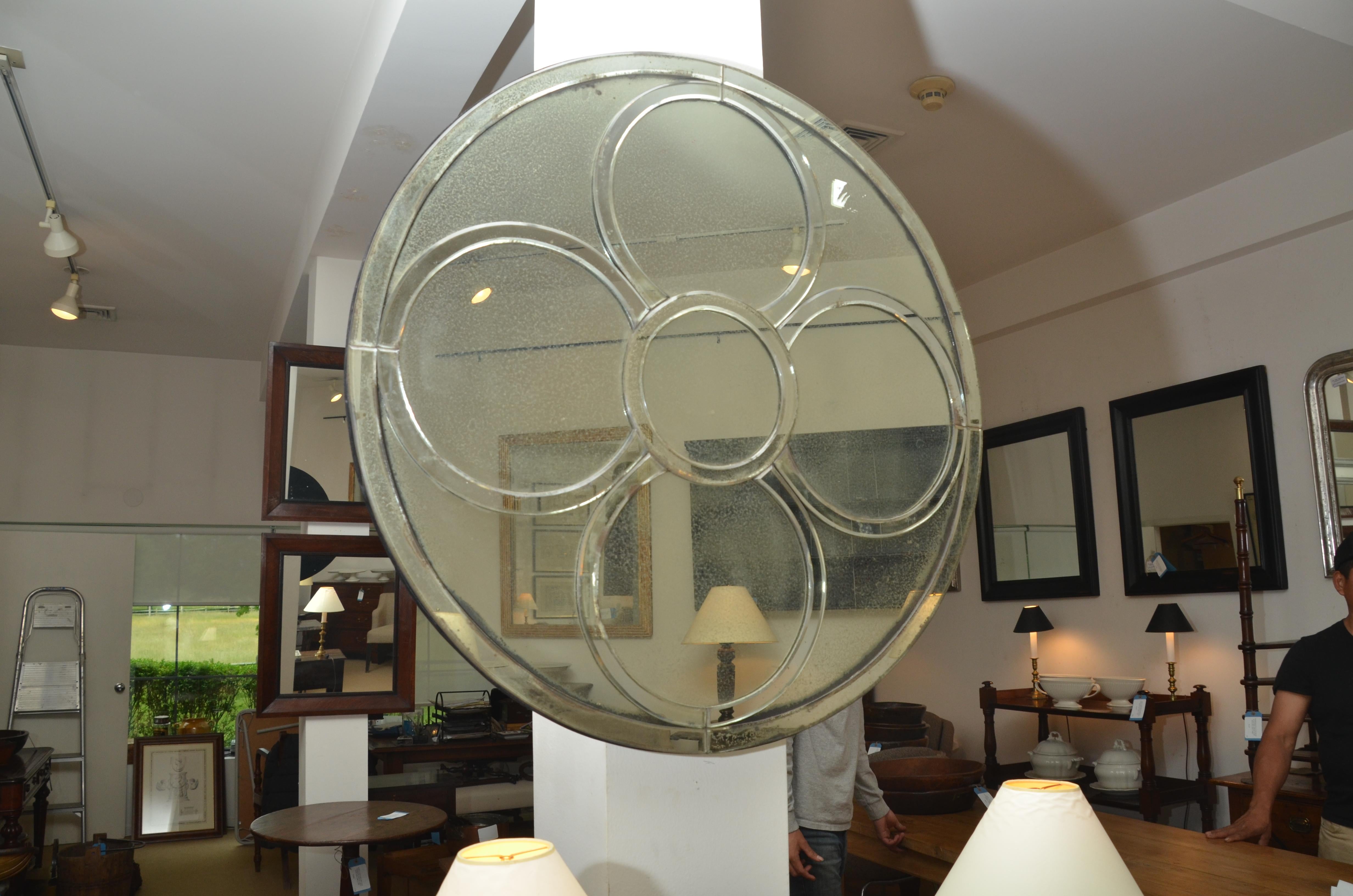 Large round mirror with five smaller round mirror circle overlays, back mounted on velvet.

   