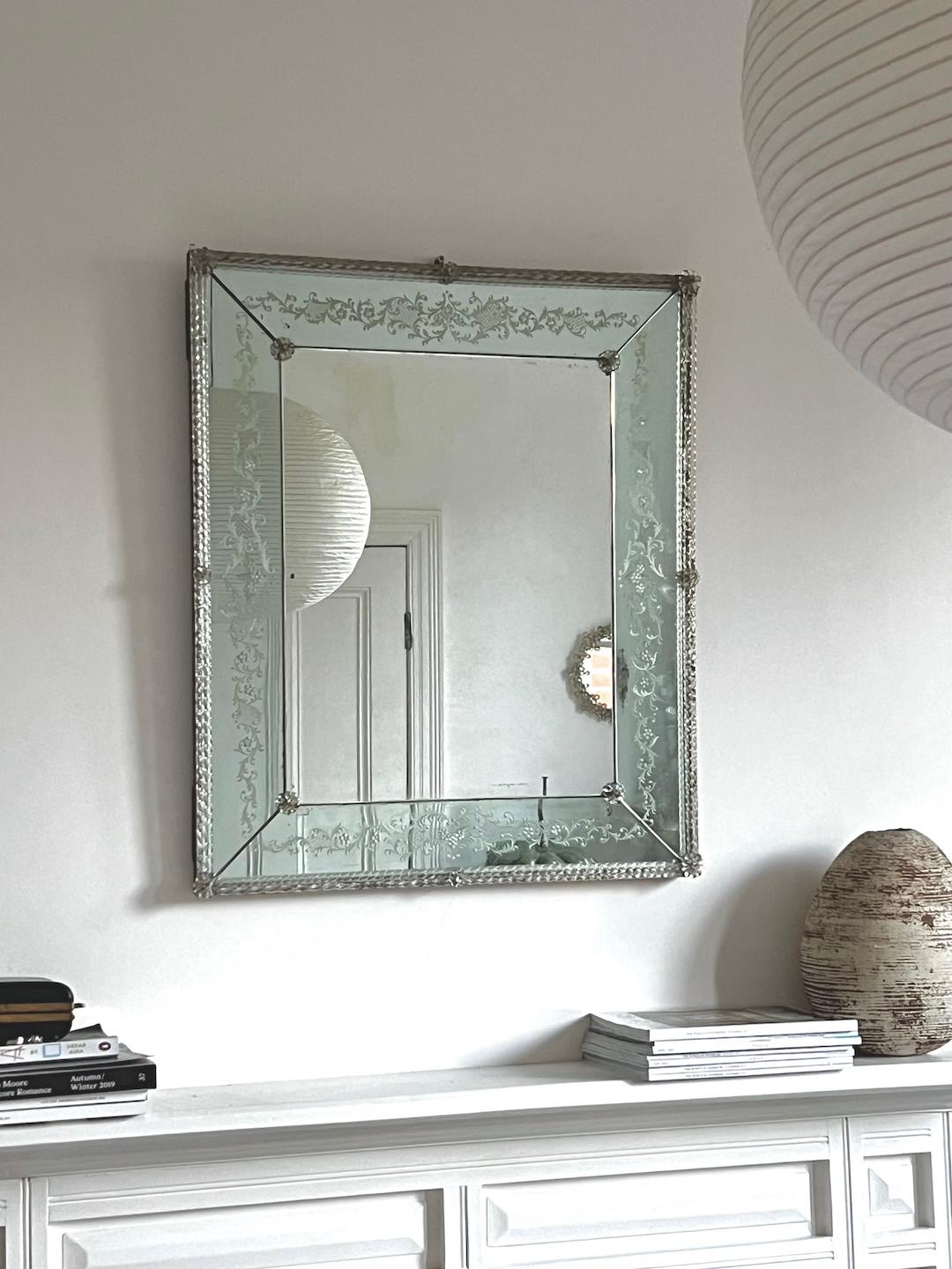 An art deco wall mirror in Venetian style, with pale blue glass frame. The frame is decorated with reverse etching and applied flowers, with three rows of barley twist glass around the edge. European, early to mid-20th century, found in