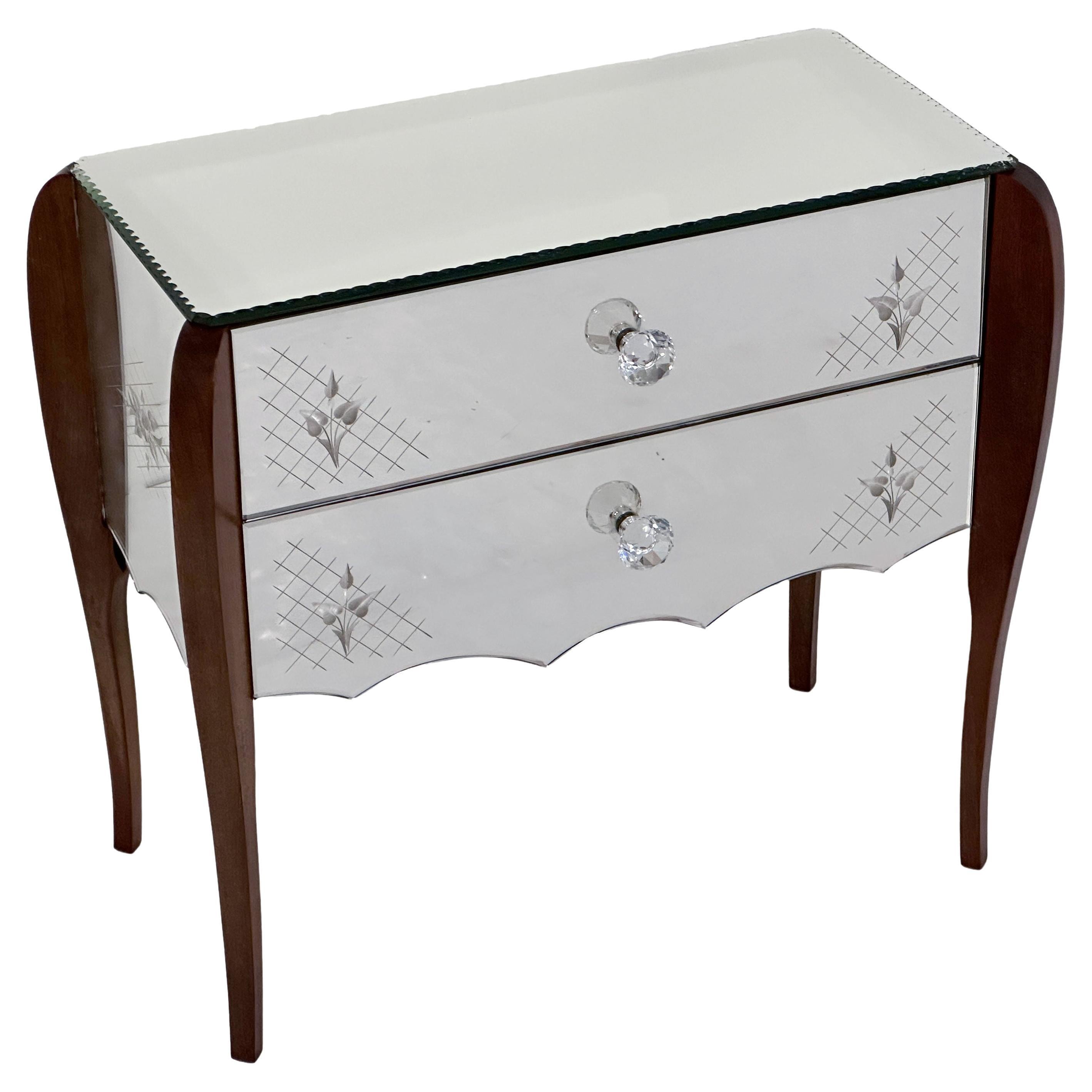 A fine Italian mirrored chest or nightstand or end table in the Venetian style, featuring a rectangular mirrored glass top over a mirrored frieze cabinet of three sides adorned with etched floral and geometric designs, and two drawers, each drawer