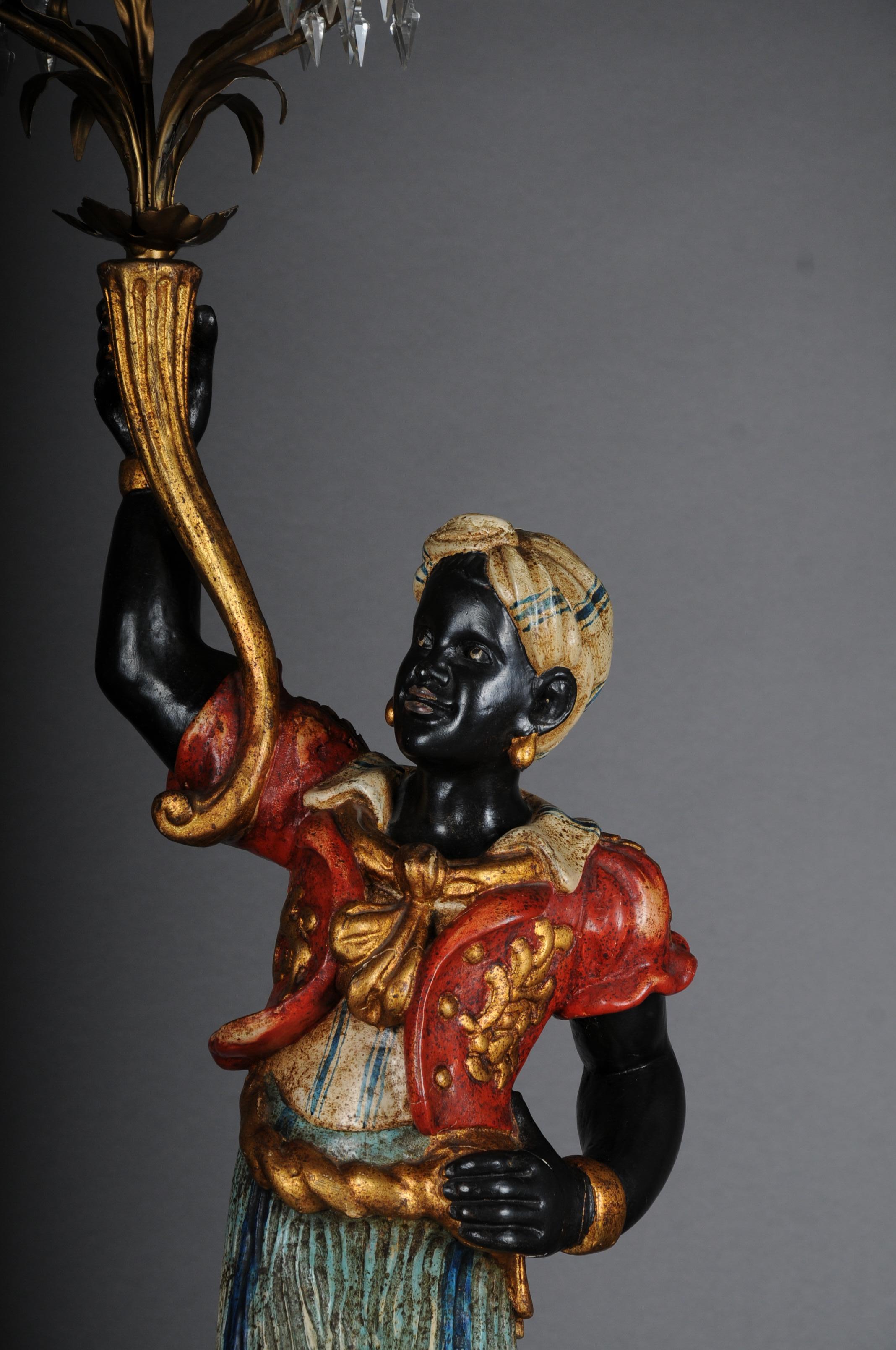 Venetian-style moroccan chandelier with an oriental woman.

Wood/stucco painted In the right hand holding a cornucopia with a 5-flame candlestick. 20th century measure: H. 180 cm. Electrified.