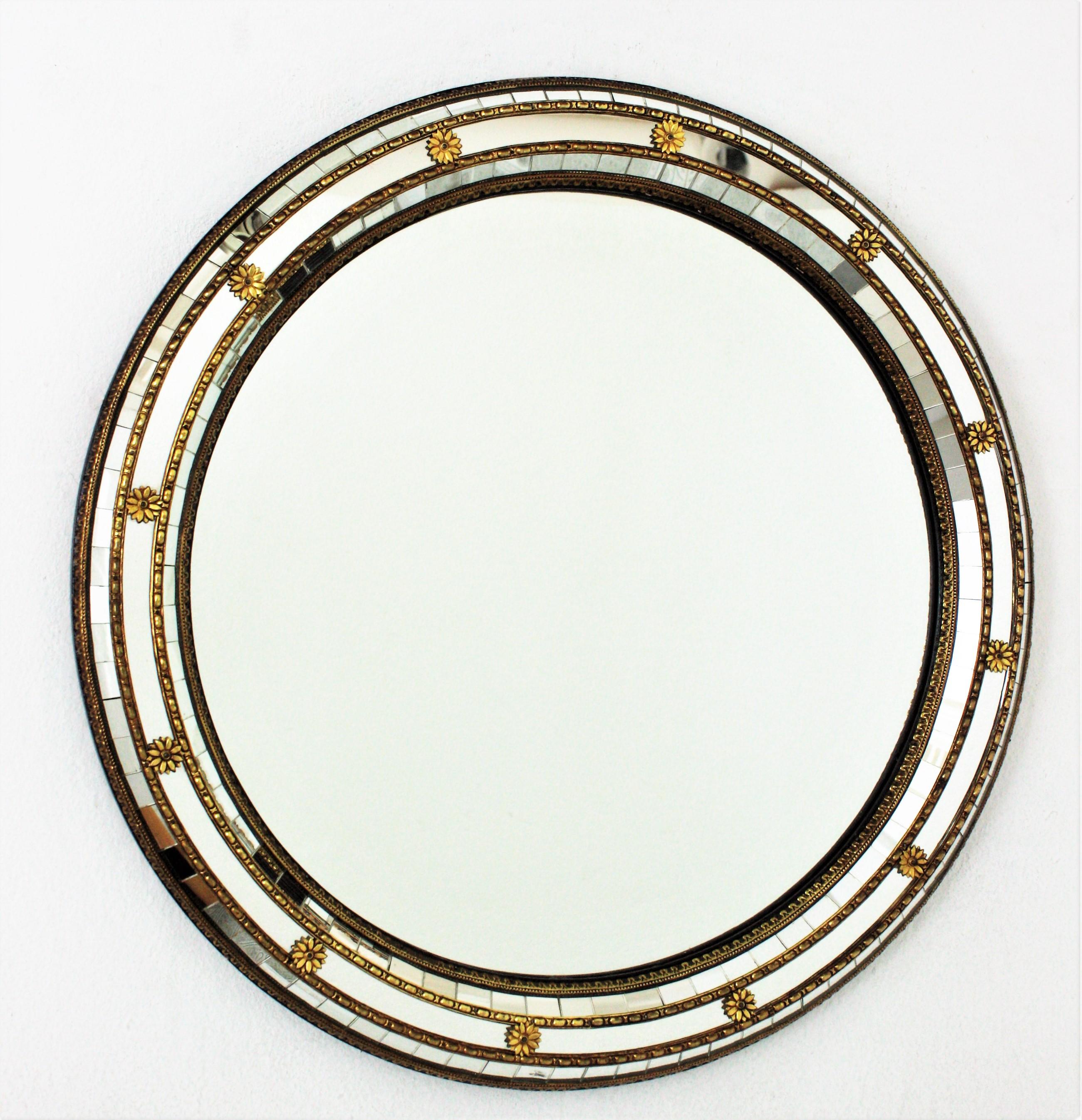 Venetian style round wall mirror with brass accents, Spain, 1950-1960s.
This circular mirror has a triple mirror frame. The mirrored panels are adorned by metal patterns and flowers.
This wall mirror will be perfect in a contemporary or classical
