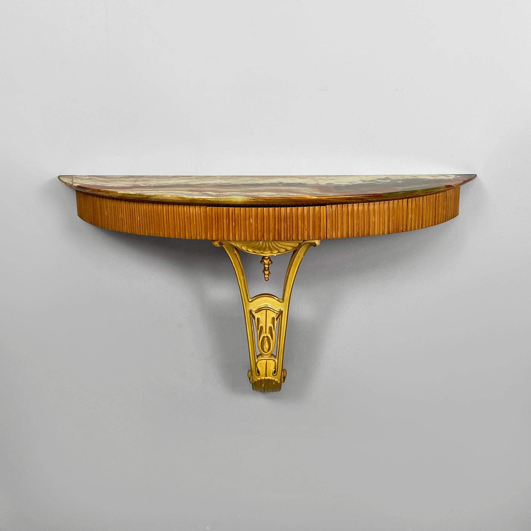 Consola de pared de estilo veneciano en mármol ónice y madera decorada, años 50
Consola de pared de estilo veneciano, con encimera de mármol ónix y estructura de madera con un cajón central. Presenta un panadizo en todo su perfil frontal y una