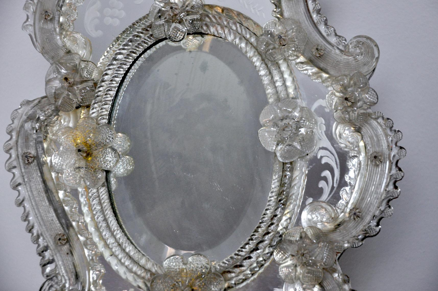 Élégant miroir de table vénitien en verre soufflé et miroir biseauté et gravé avec son support en bois d'époque. Conçu et produit en Italie au début du XXe siècle. Petits défauts liés à l'âge de l'objet, support en parfait état. Objet de design