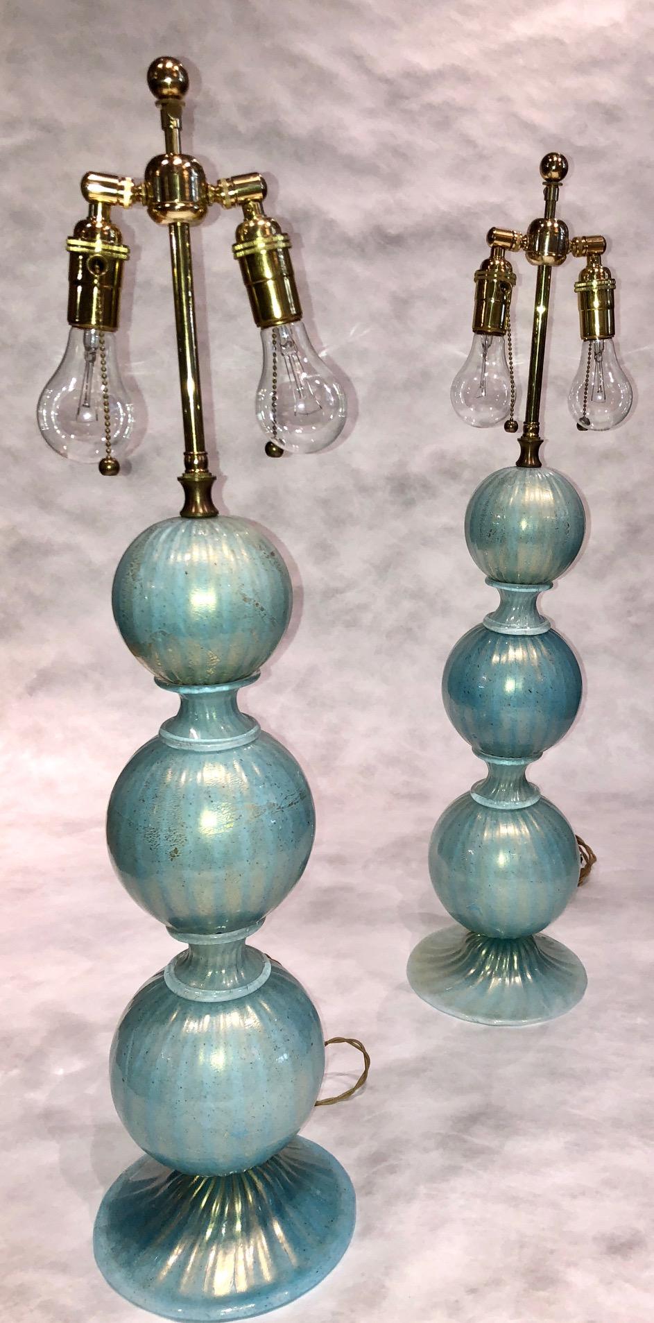 hand blown Venetian table lamps in Turqouise Murano glass with 24-karat gold flecks, circa 1960s
Featuring three ribbed orbital forms ascending from a gently concave base.
2 adjustable bulbs on ea lamp. US wiring. In very good condition.
Lamp