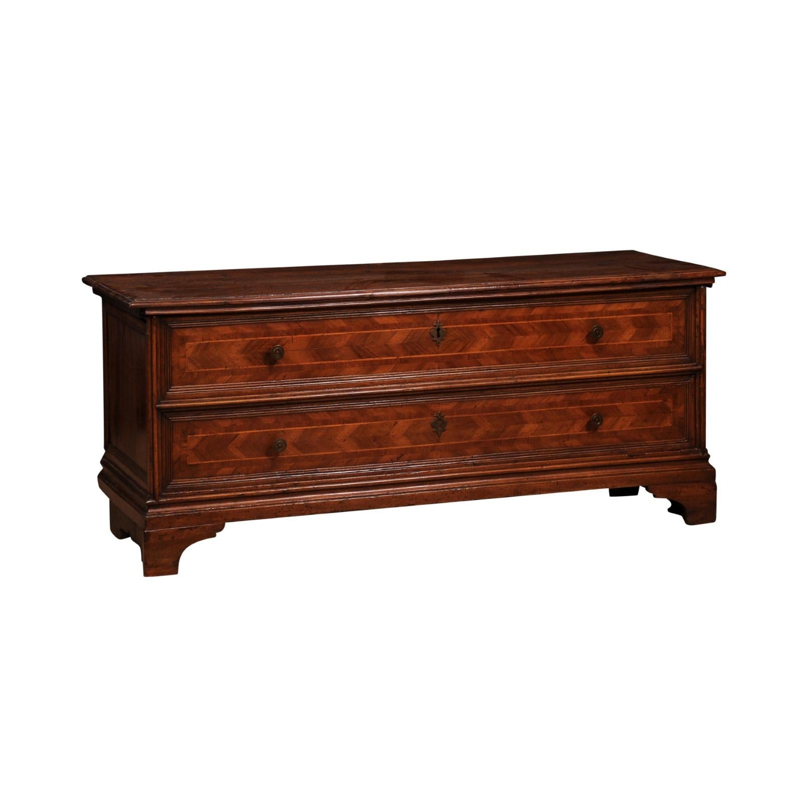 A Venetian walnut and mahogany blanket chest from the 20th century with marquetry décor and faux drawers. Experience the enchantment of Venice with this exquisite 20th-century Venetian walnut and mahogany blanket chest, a delightful blend of