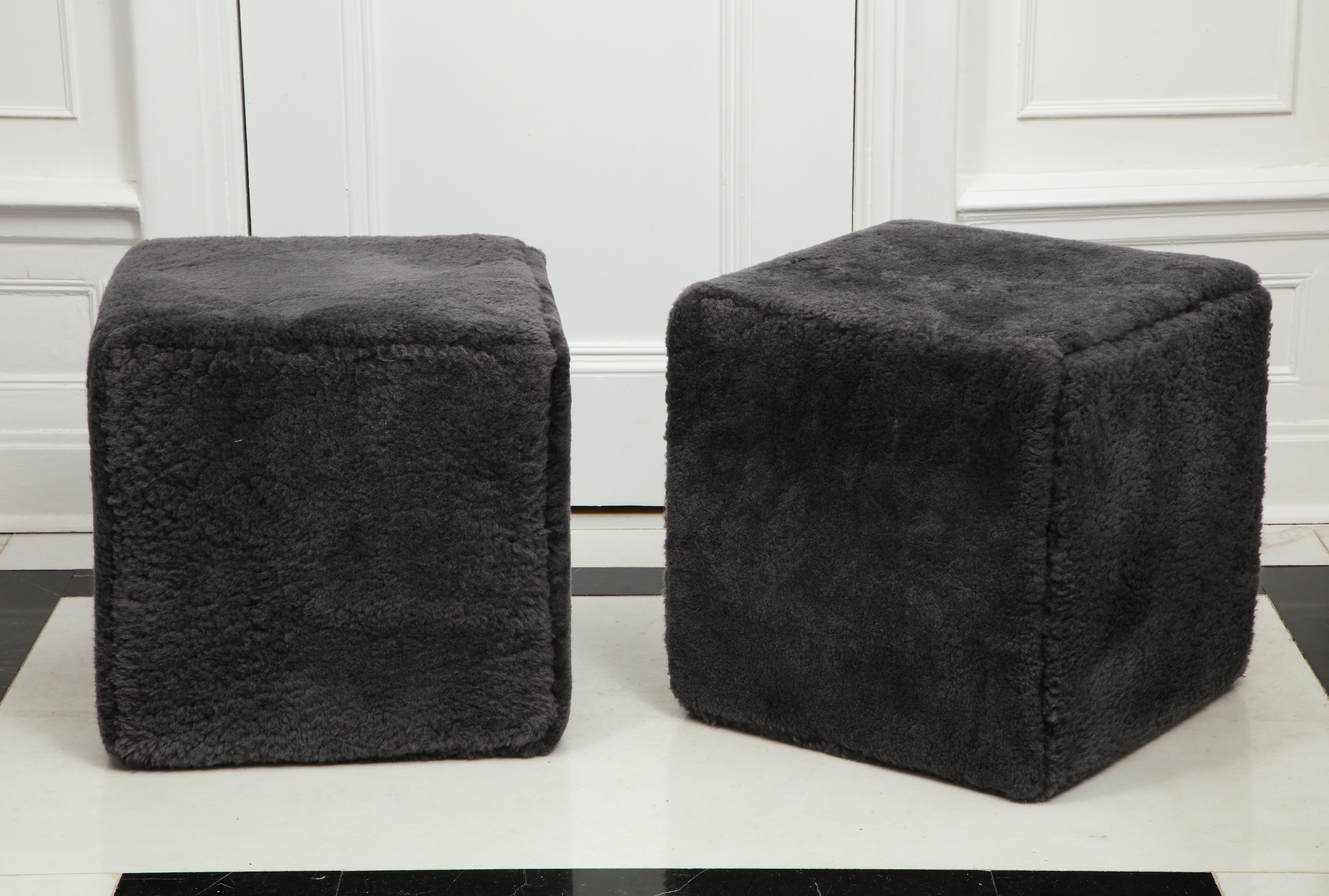 Pair of custom shearling cube ottomans/footstools designed by Venfield. The pair shown in the photos are in black color. Custom options are available for different sizes and shearling colors.