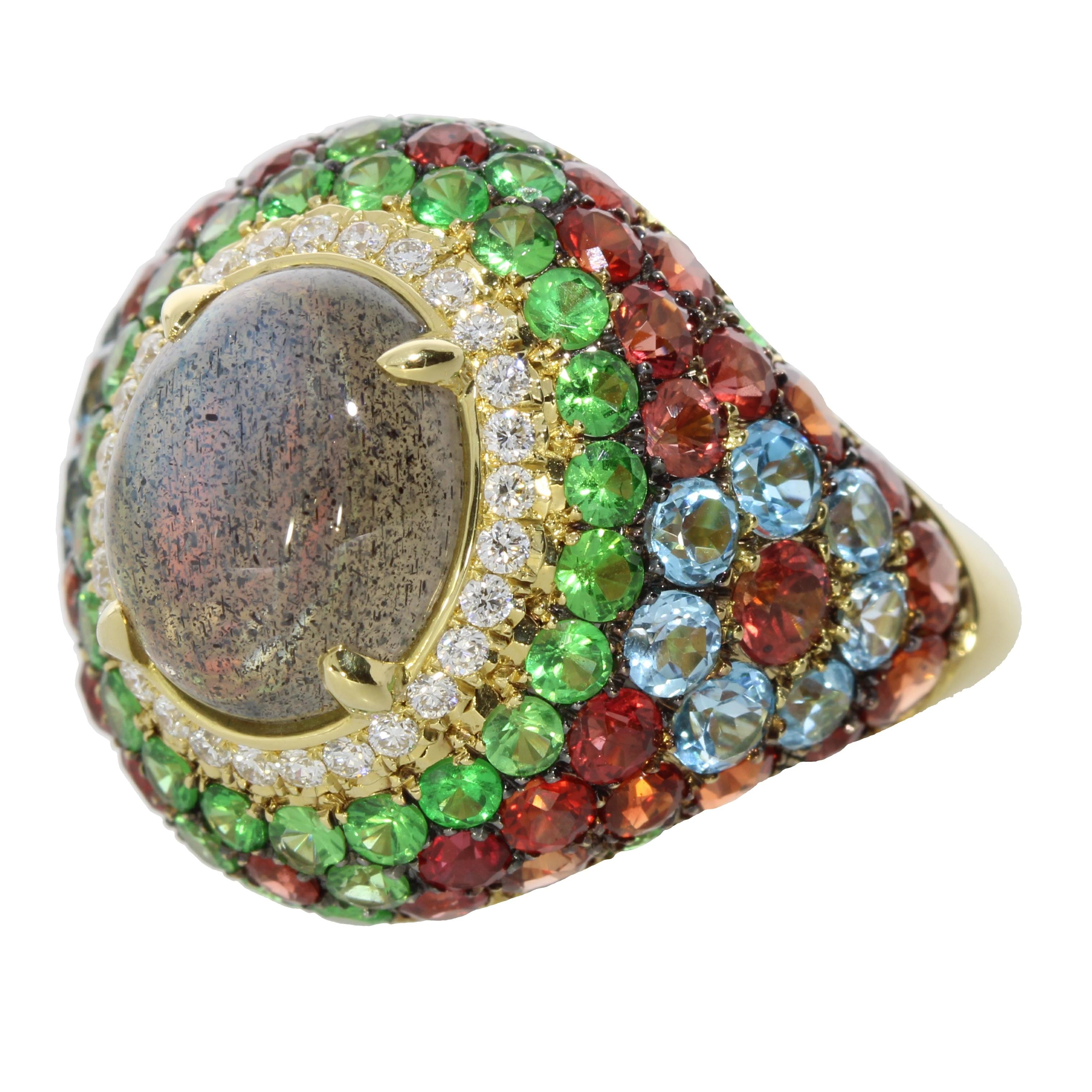 A delicate cocktail ring of brilliant cut diamonds encircle a mesmerising oval cut grey labradorite cabochon, expertly contrasting against the harmonious mix of garnets, tsavorites, blue topaz and orange sapphires.

Details
Labradorite and Diamonds
