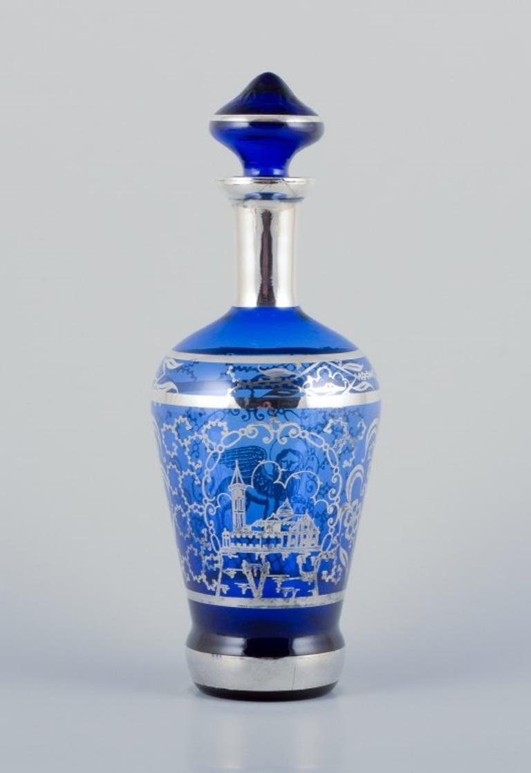 Venice, Italy. A liqueur set in blue glass consisting of a decanter and five glasses. Hand-painted with silver decoration featuring Venice motifs. Hand blown glass.
Mid-20th century.
Perfect condition.
Decanter: H 26.0 cm including stopper x D 10.0