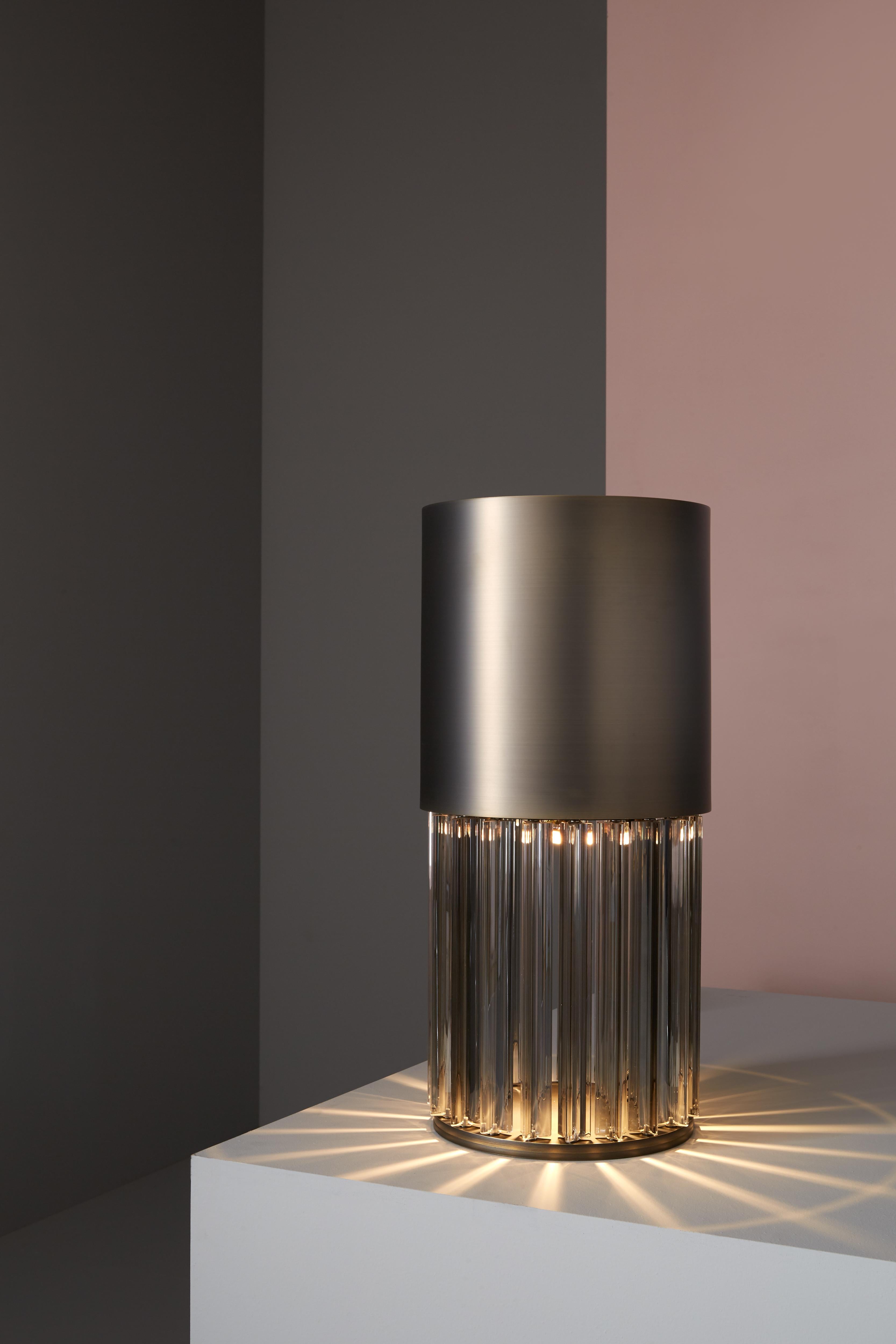 Table lamp with diffused light. Dark bronze striped structure and crystal, amber or smoke grey Murano blown glass trihedrons.
Specifications:
Function: Table
Location: Interior
Light emission: Diffused light
Light source: 1×4W GU10 PAR16 LED