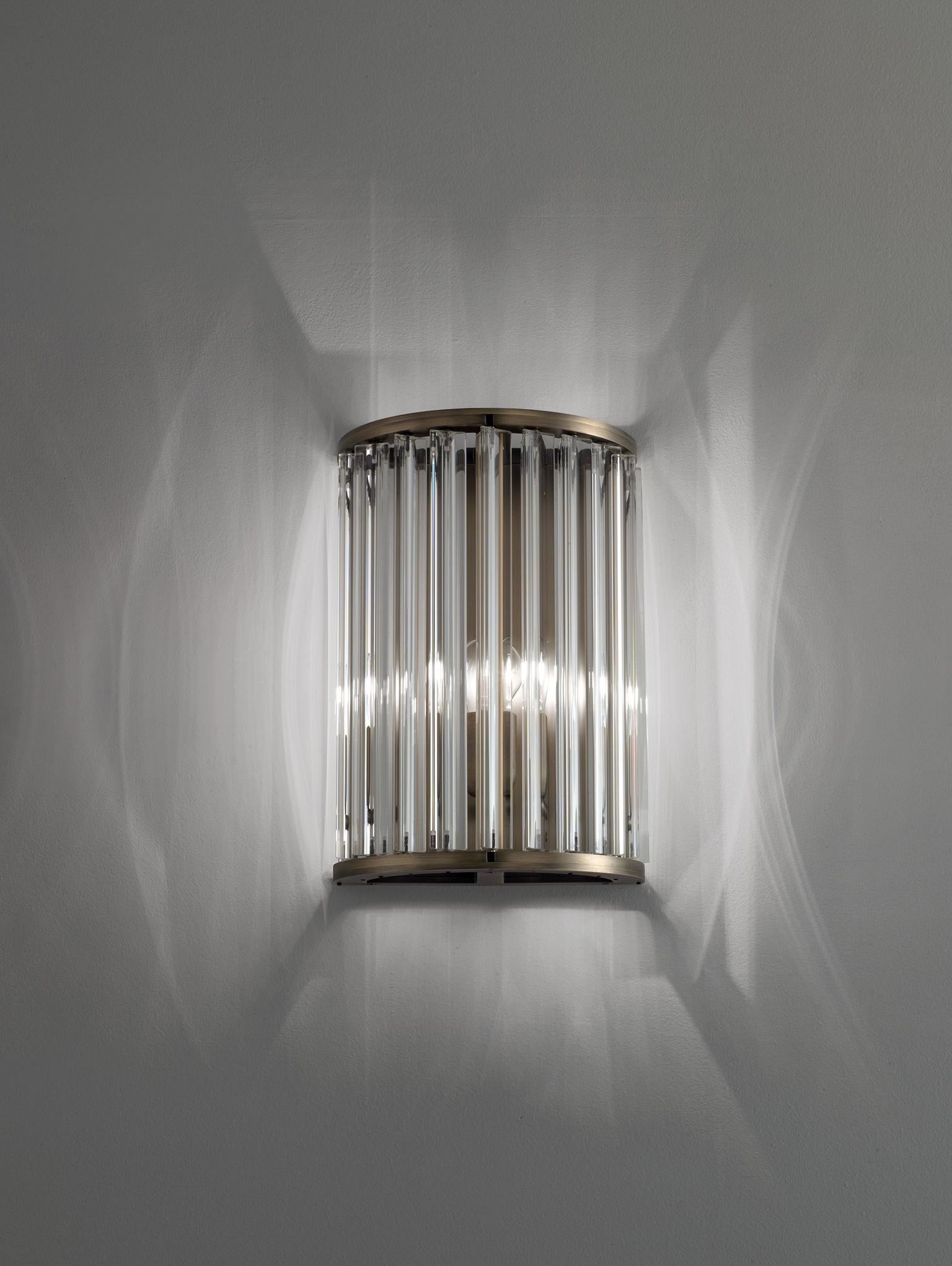 Wall lamp with diffused light. Matte black nickel or light burnished brass structure and crystal, amber or smoke grey Murano blown glass trihedrons. Specifications: Function: Wall Location: Interior Light Emission: Diffused light Light Source: