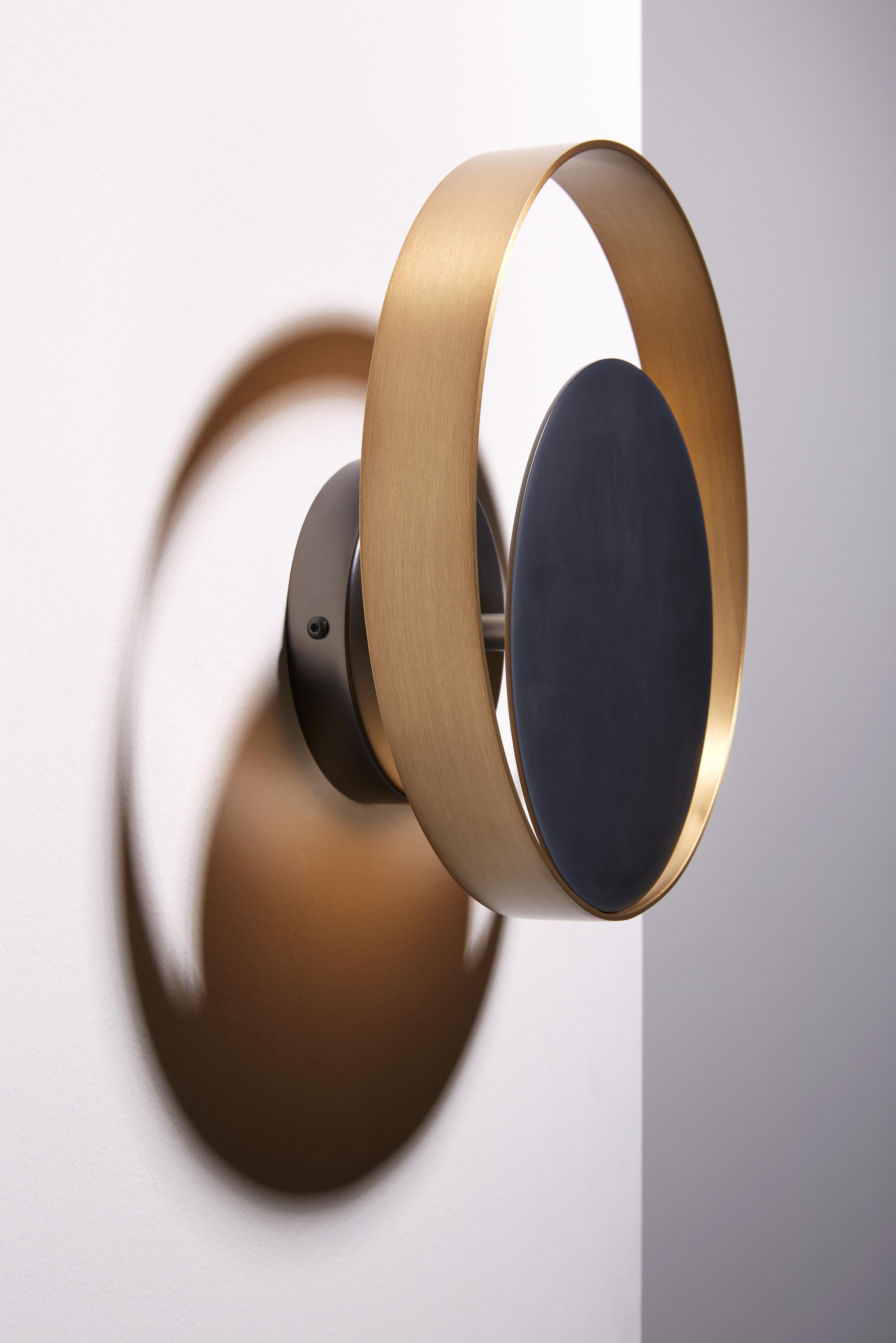 Wall lamp with indirect light. Light burnished brass ring and matte black nickel structure.

Location: Interior
Light Source: 1×17W 1500lm 2700°K CRI90
Voltage: 110 - 120 V / 220 - 240 V
Frequency: 50 - 60 Hz
Dimmable: Yes
Mounting: Wall.