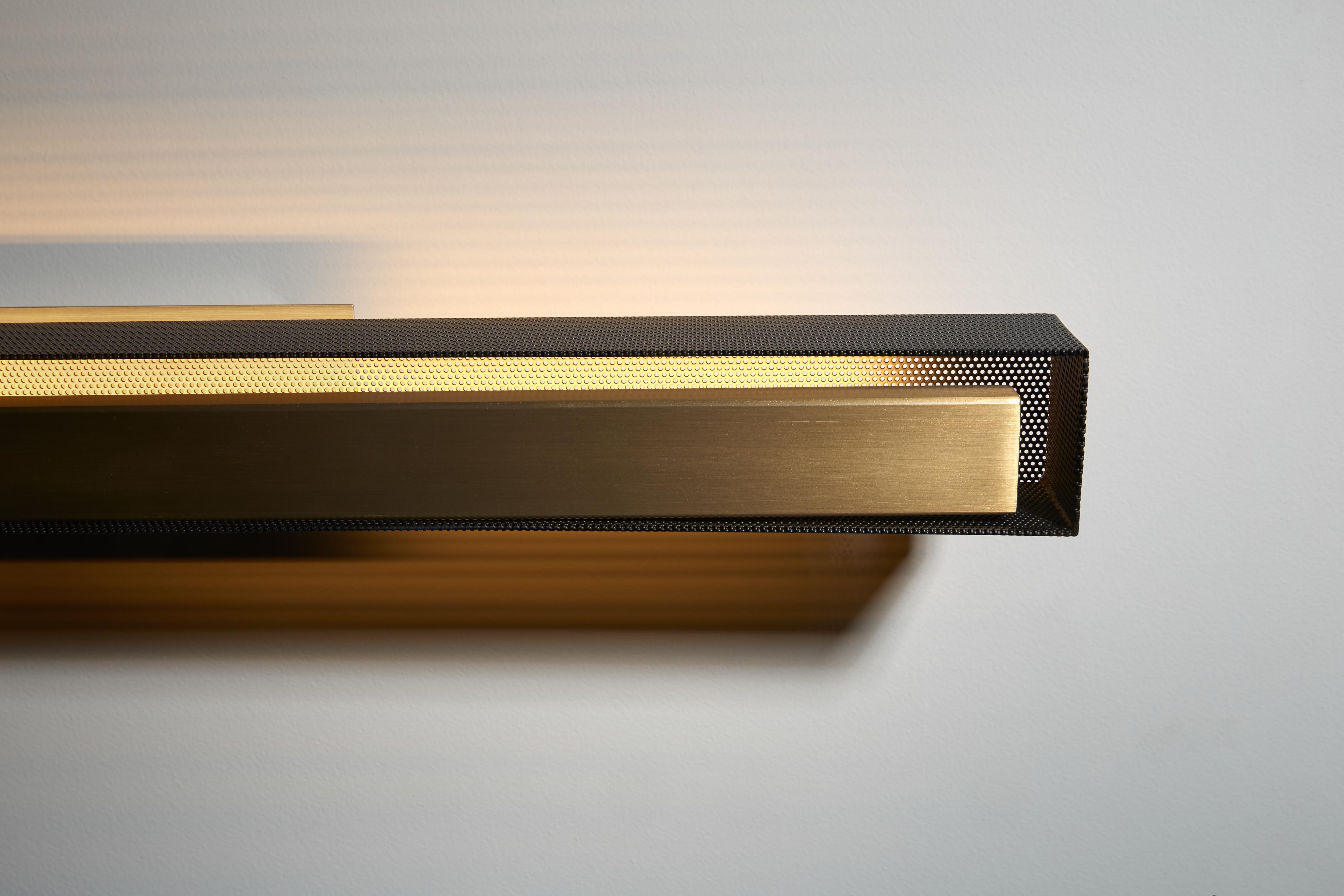 Wall lamp with indirect light. Light burnished brass structure and matte black perforated metal lampshade.
 
Location: Interior
Light source: 1×13W LED 1330lm 2700°K CRI90
Voltage: 110 - 120 V / 220 - 240 V
Frequency: 50 - 60 Hz
Ballast: