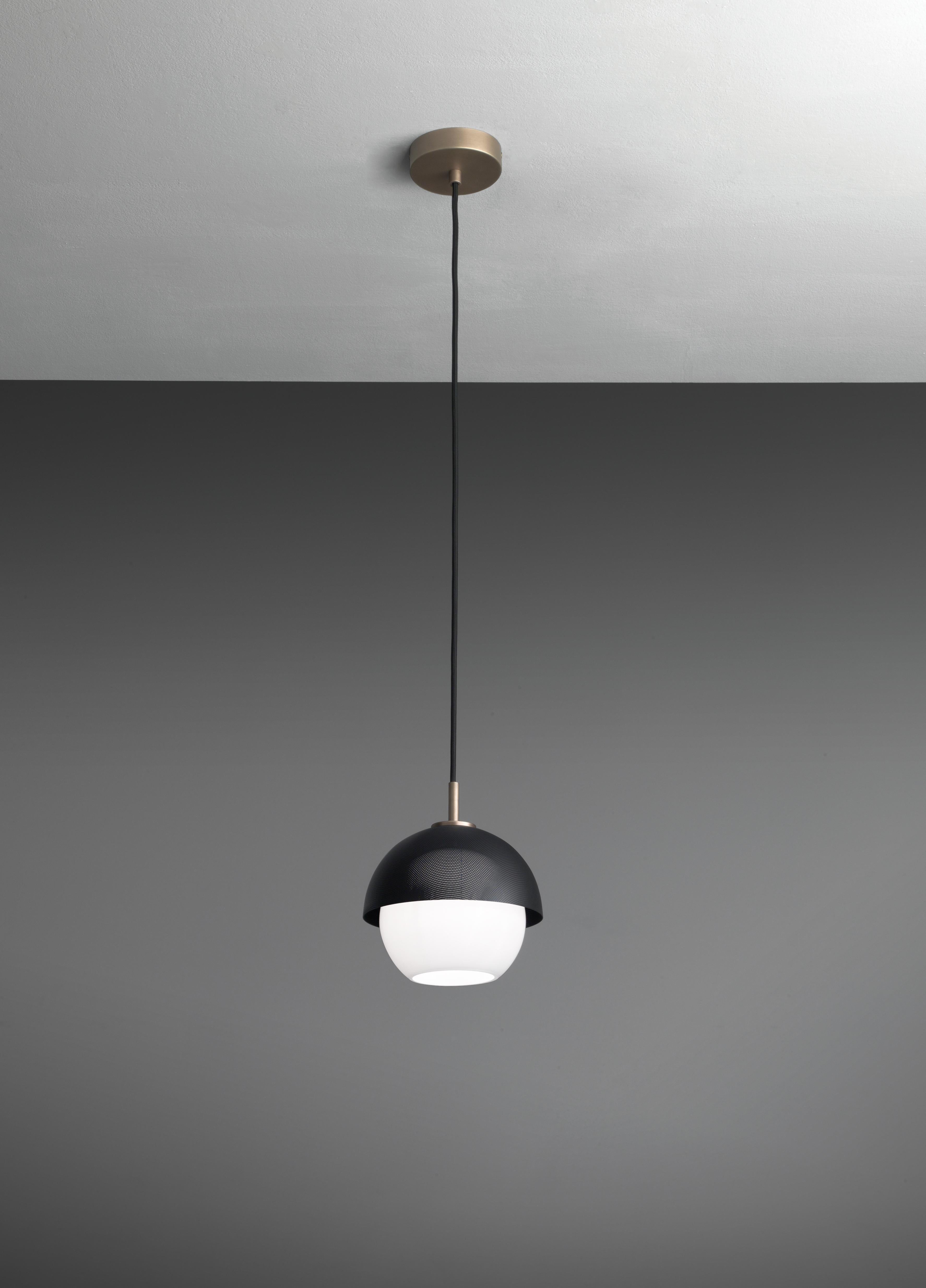 Suspended lamp with diffused light. Light burnished brass structure with matte gold or matte black perforated metal lampshade. White Murano blown glass diffuser.
Specifications:
Function: Suspension
Location: Interior
Light emission: Diffused