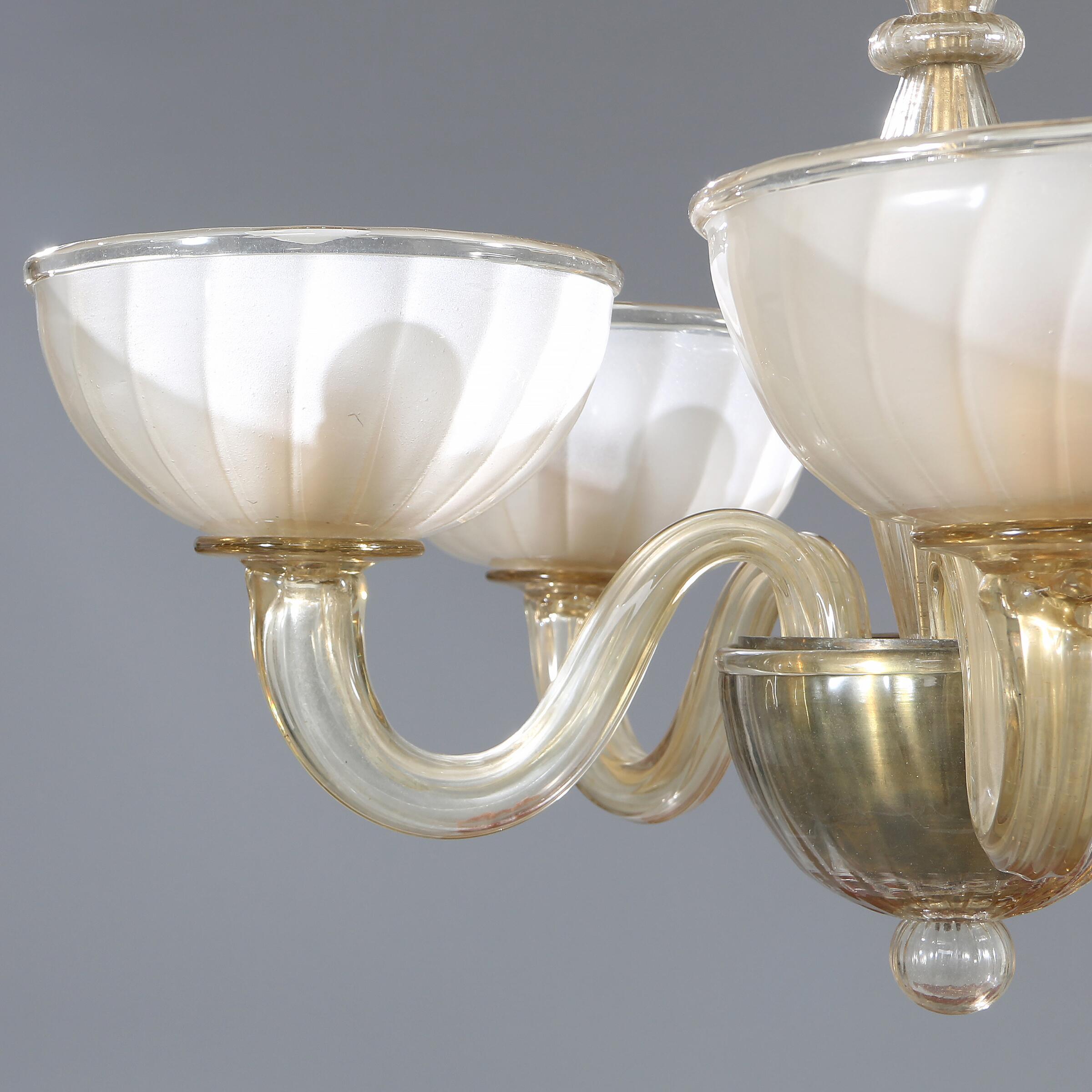 An Italian glass chandelier with five curved arms mounted for electricity. Stamped VENINI, Murano. 20th century. H. 63 cm. Diam. 61 cm.

Presumably 1930s edition. 