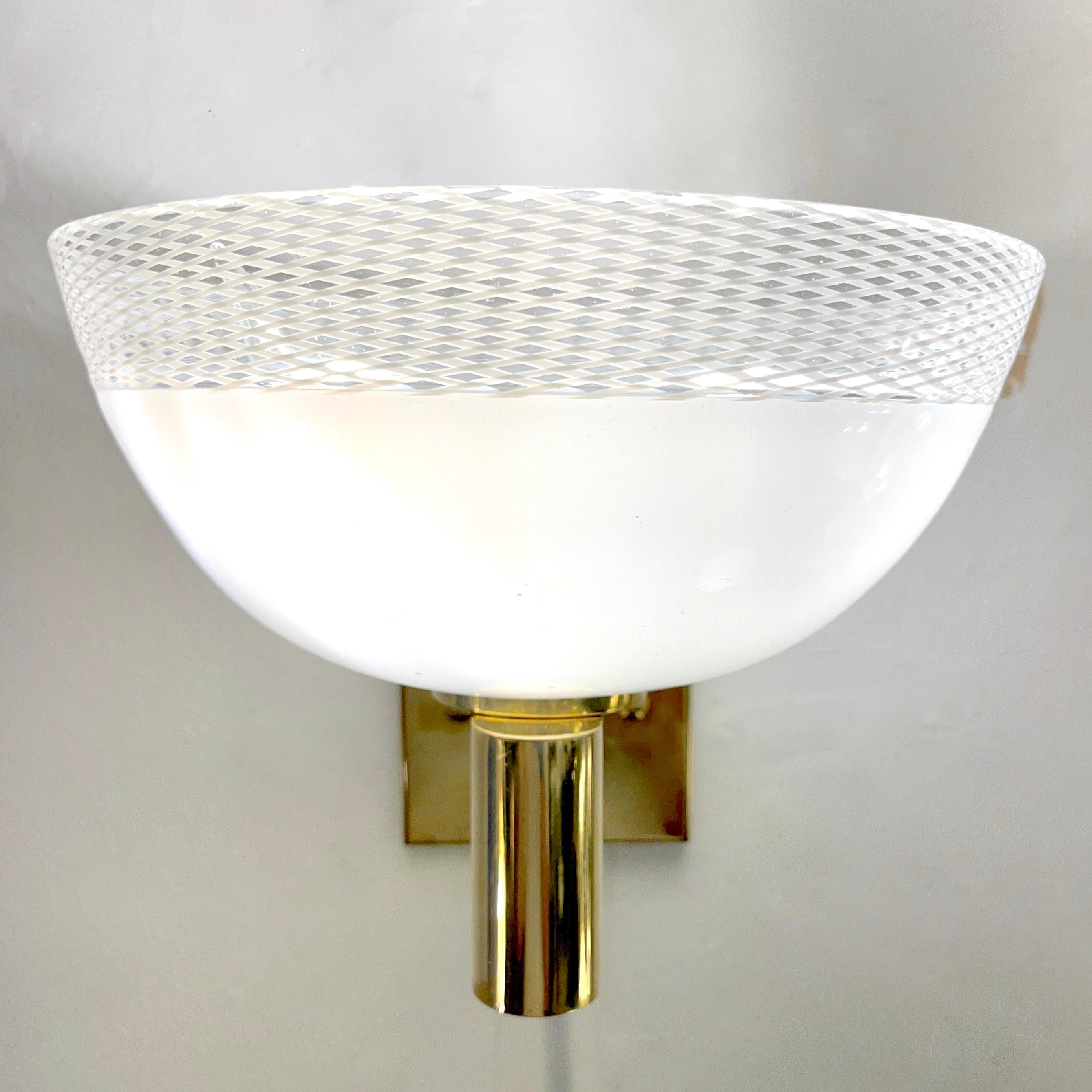 Mid-Century Modern Venetian sconces of organic design with Hollywood glamour, a vintage Art Deco creation in the style of Venini, circa 1970s, entirely handcrafted in Italy on Murano Island. The half-moon bowls in high-quality white blown Murano