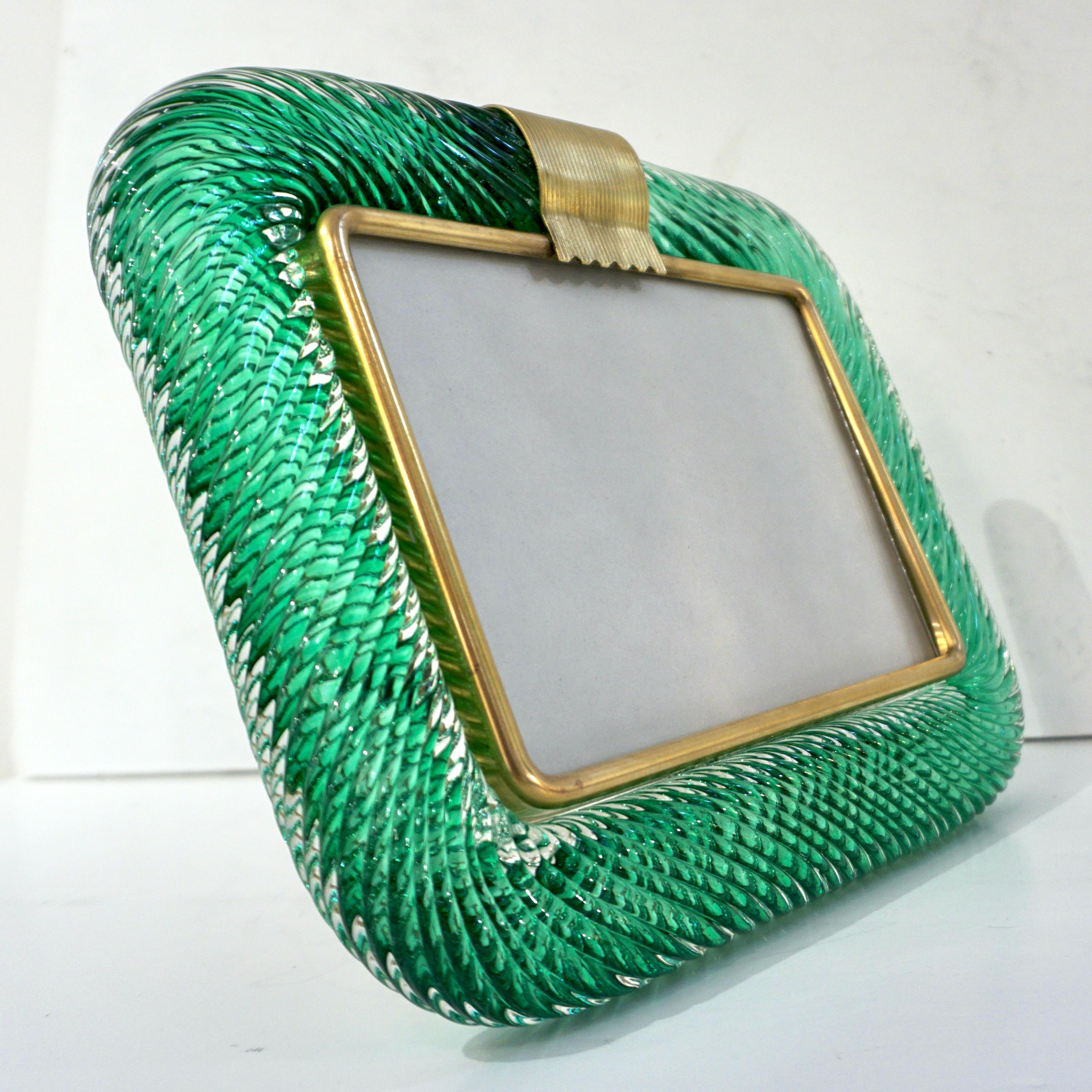 A sophisticated Venetian modern design horizontal picture frame in thick blown crystal clear Murano glass decorated with a Sommerso inset ribbon in luscious emerald green color, by Venini, signed piece. The elegant texture of the tightly twisted