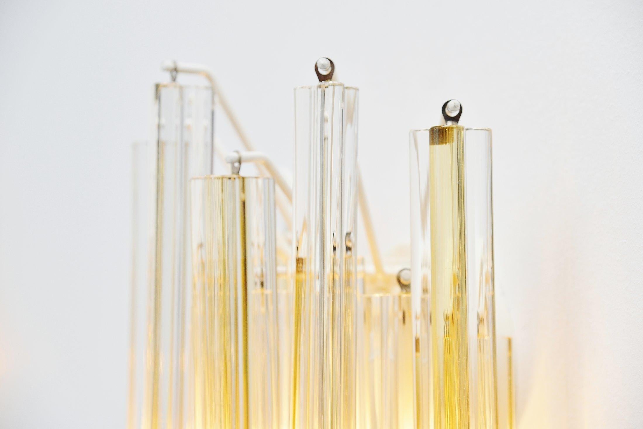 Nice pair of sconces designed by Paolo Venini, manufactured by Venini Murano, Italy, 1960. These sconces have several transparent / yellow glass pegs called asta triedo. The pegs are all in good condition and hang on a white painted wall frame. The