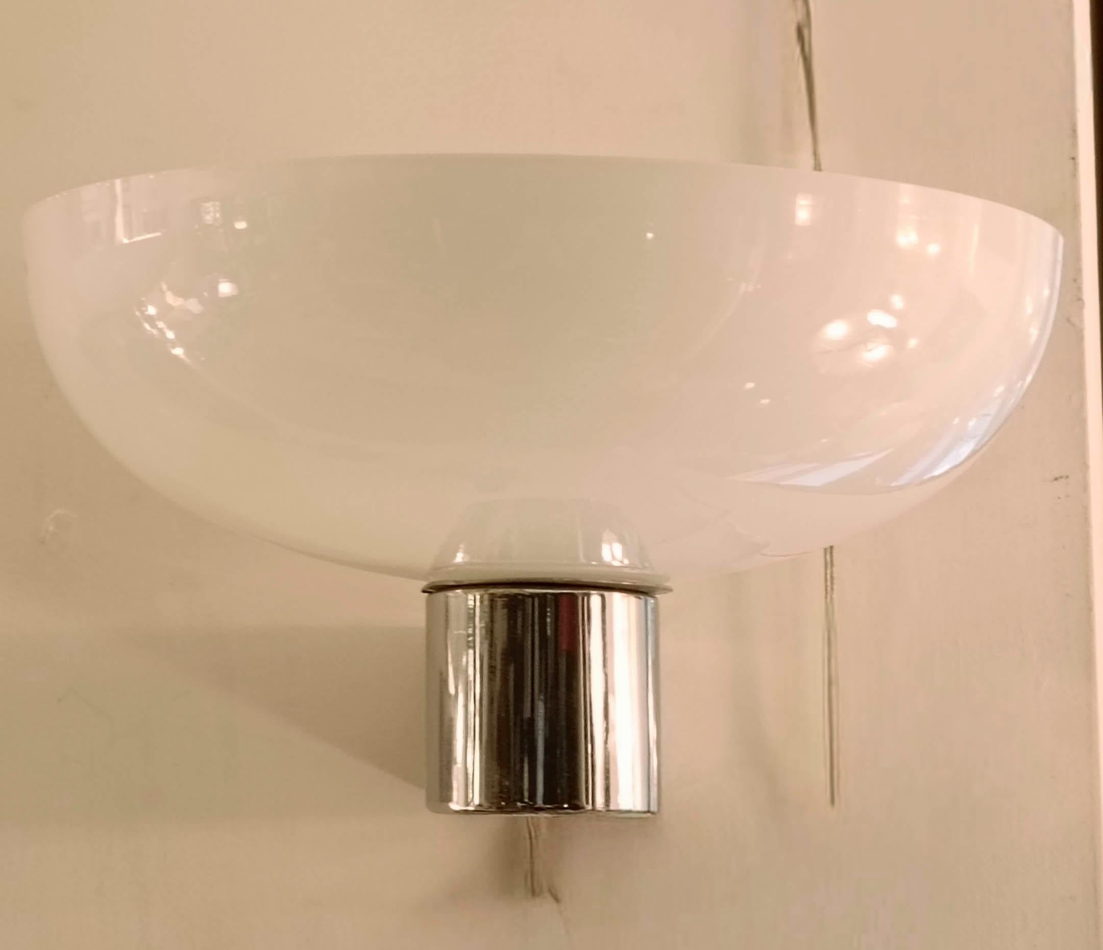 La lámpara tiene un diseño limpio y minimalista, típico del estilo italiano de los años cincuenta. La combinación de vidrio soplado lechoso y latón cromado es un clásico de la época.
La lámpara consta de un difusor de cristal blanco en forma de