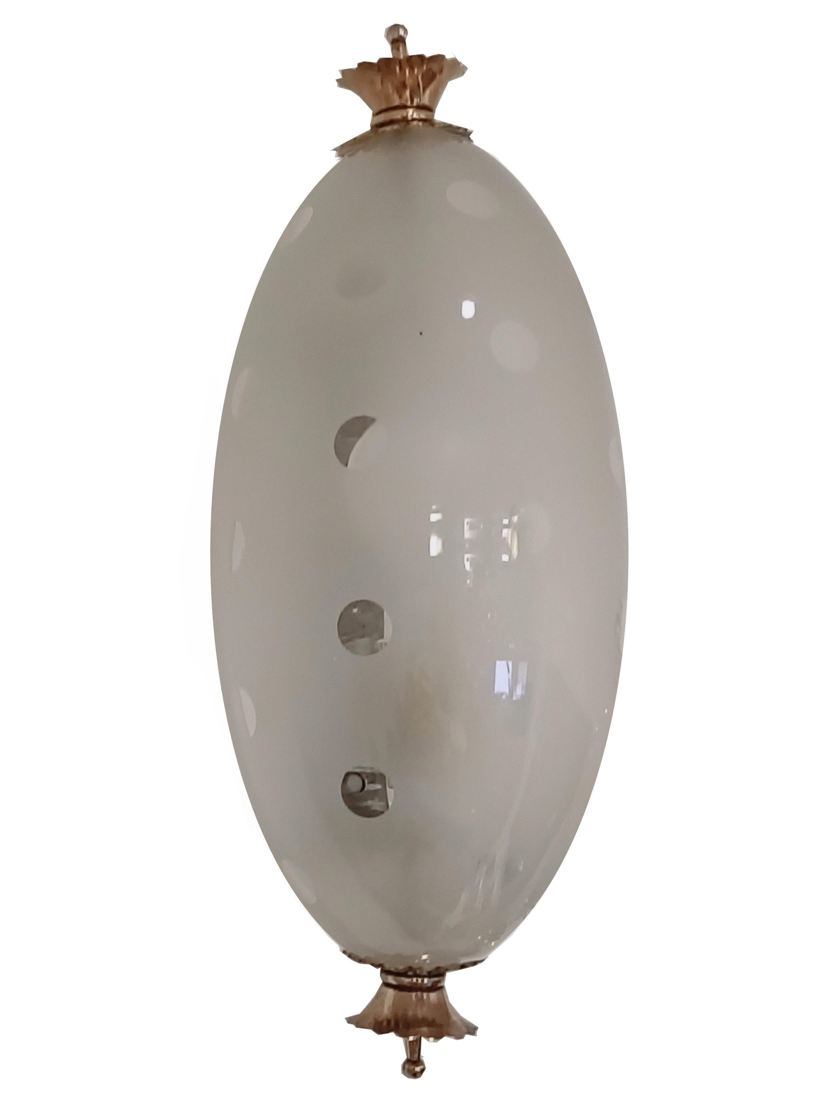 Aplique refinado y delicado de cristal de Murano blanco y latón. 
El aplique tiene dos coronas de latón, sobre las que se ha montado un hermoso cuenco de cristal de Murano blanco arenado con lunares transparentes. 
