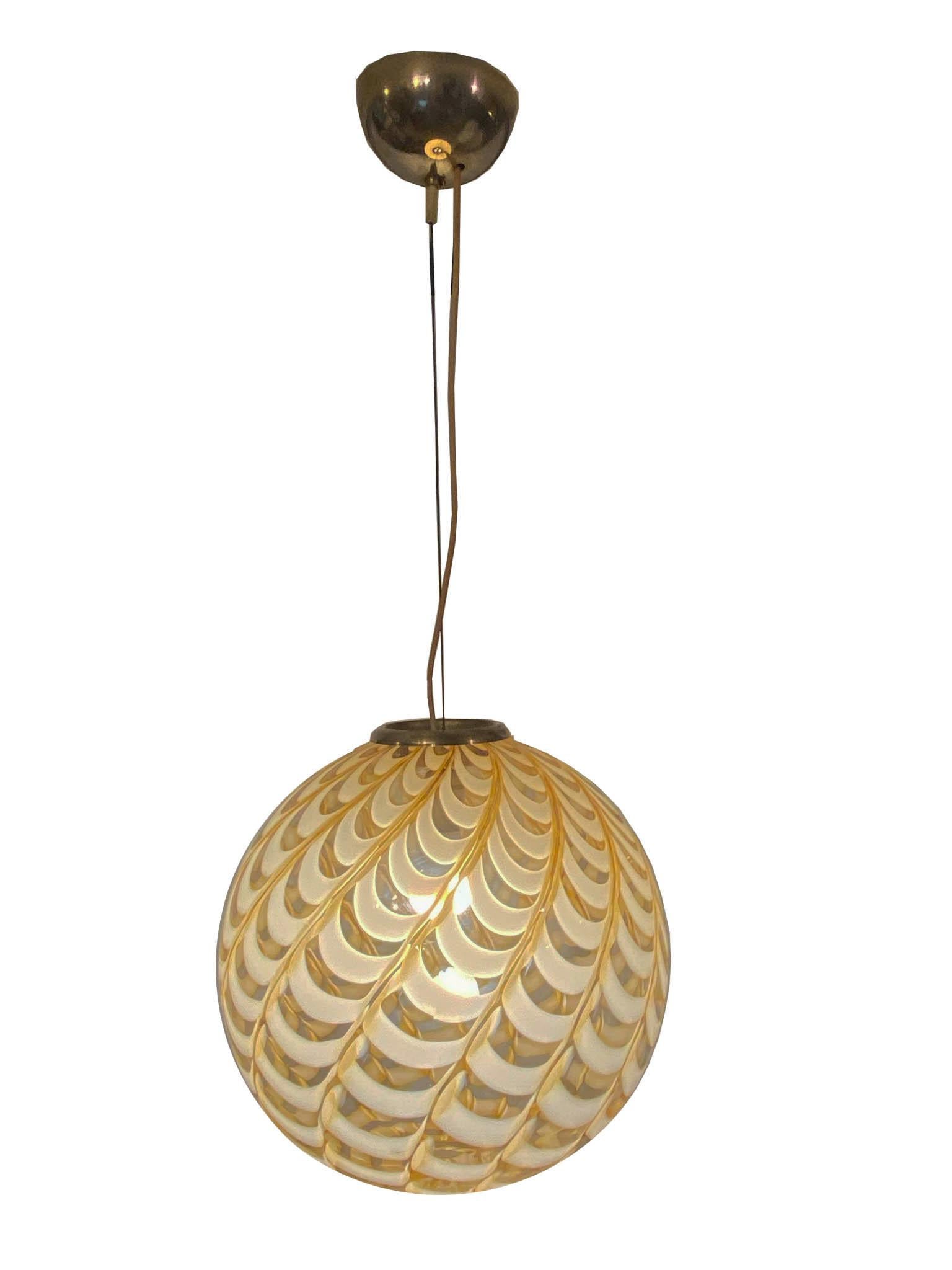 Italian Murano glass pendant lamp attributed to Venini with swirling combinations that create a beautiful wave design, in caramel color and clear glass.