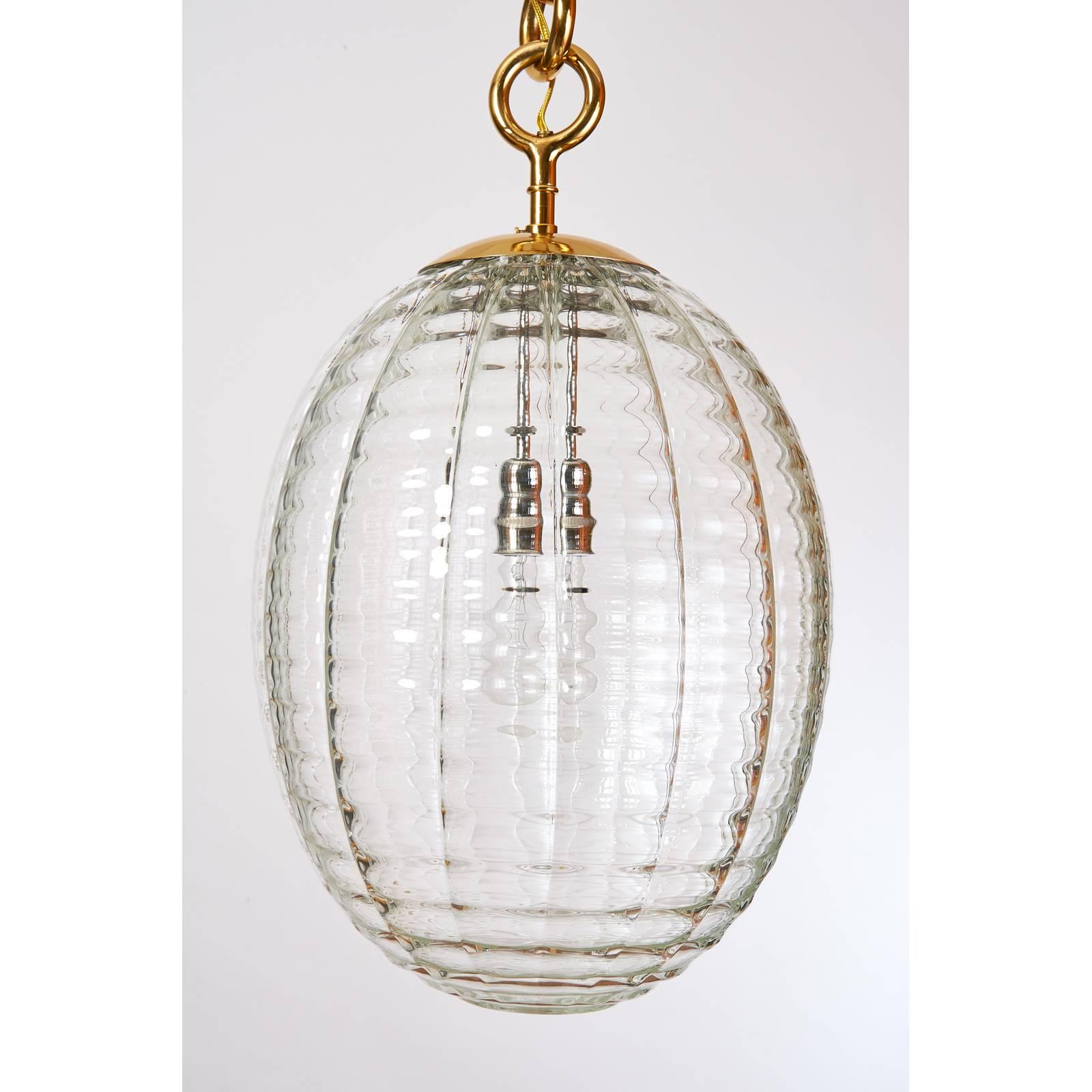 Venini
Oval lantern or pendant in blown rippled glass by Venini
Polished brass mounts with handsome circular link chain suspension
Italy, 1950s
Dimensions: 12 Ø x 34 H ( Body: 16 + 18 chain with canopy )
Rewired for use in the US with one standard