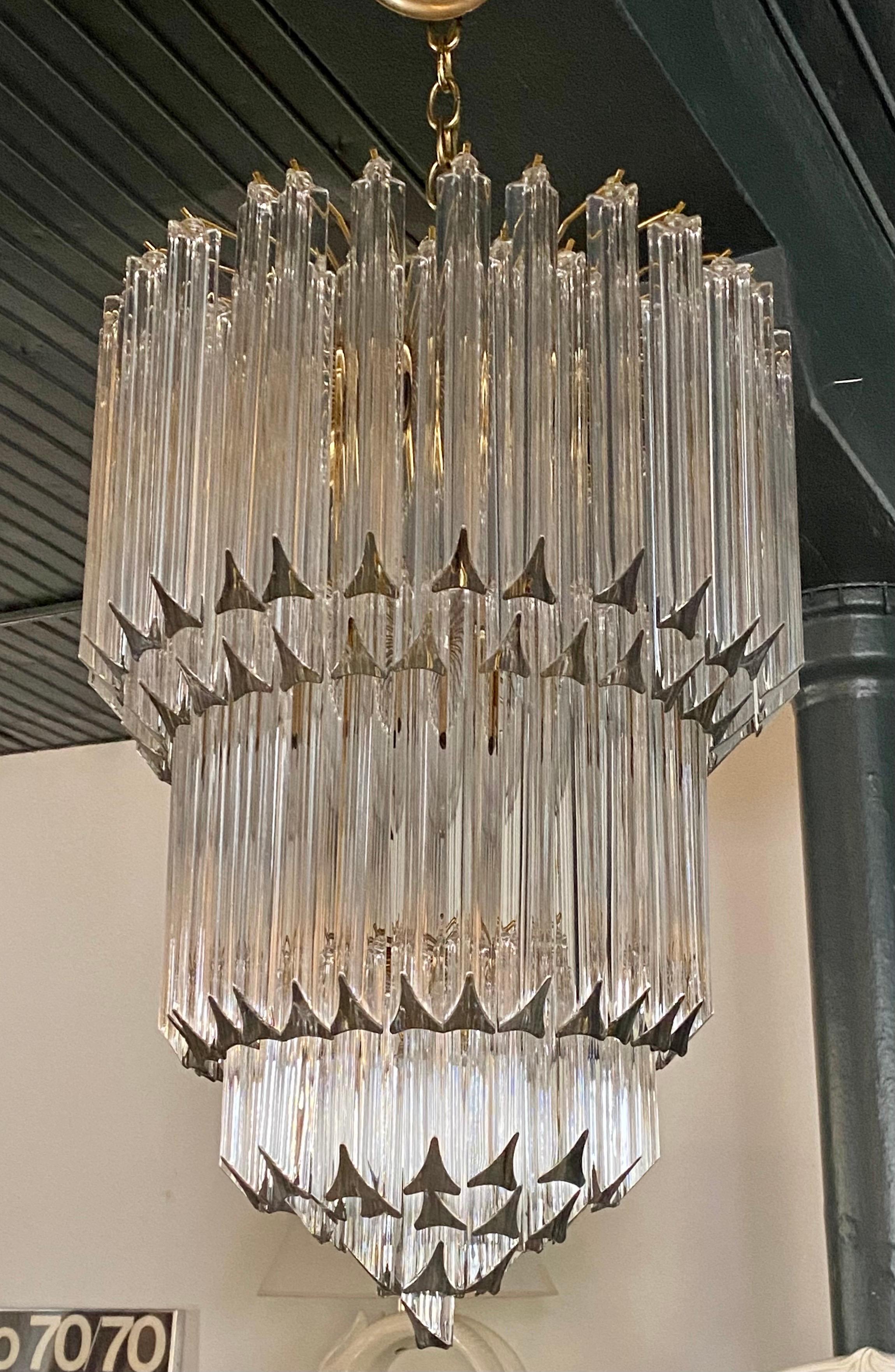 Large and Grand round Mid-Century Modern glass and brass seven-tier waterfall chandelier in the style of Venini Camer, Italy.
This impressive sculptural wedding cake chandelier is constructed of 125 clear solid crystal glass prisms. Would be great