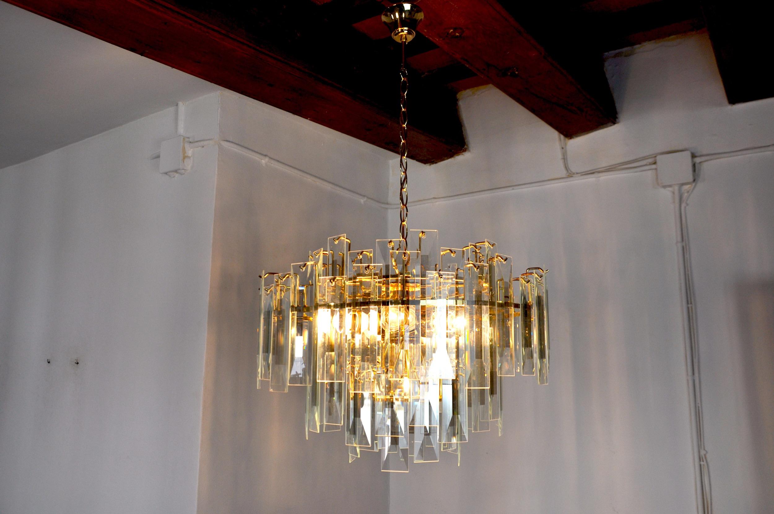 Superb venini chandelier designed and produced in italy in the 70s.

Beveled crystals distributed on a gilded metal structure.

Unique object that will illuminate wonderfully and bring a real design touch to your interior.

Verified