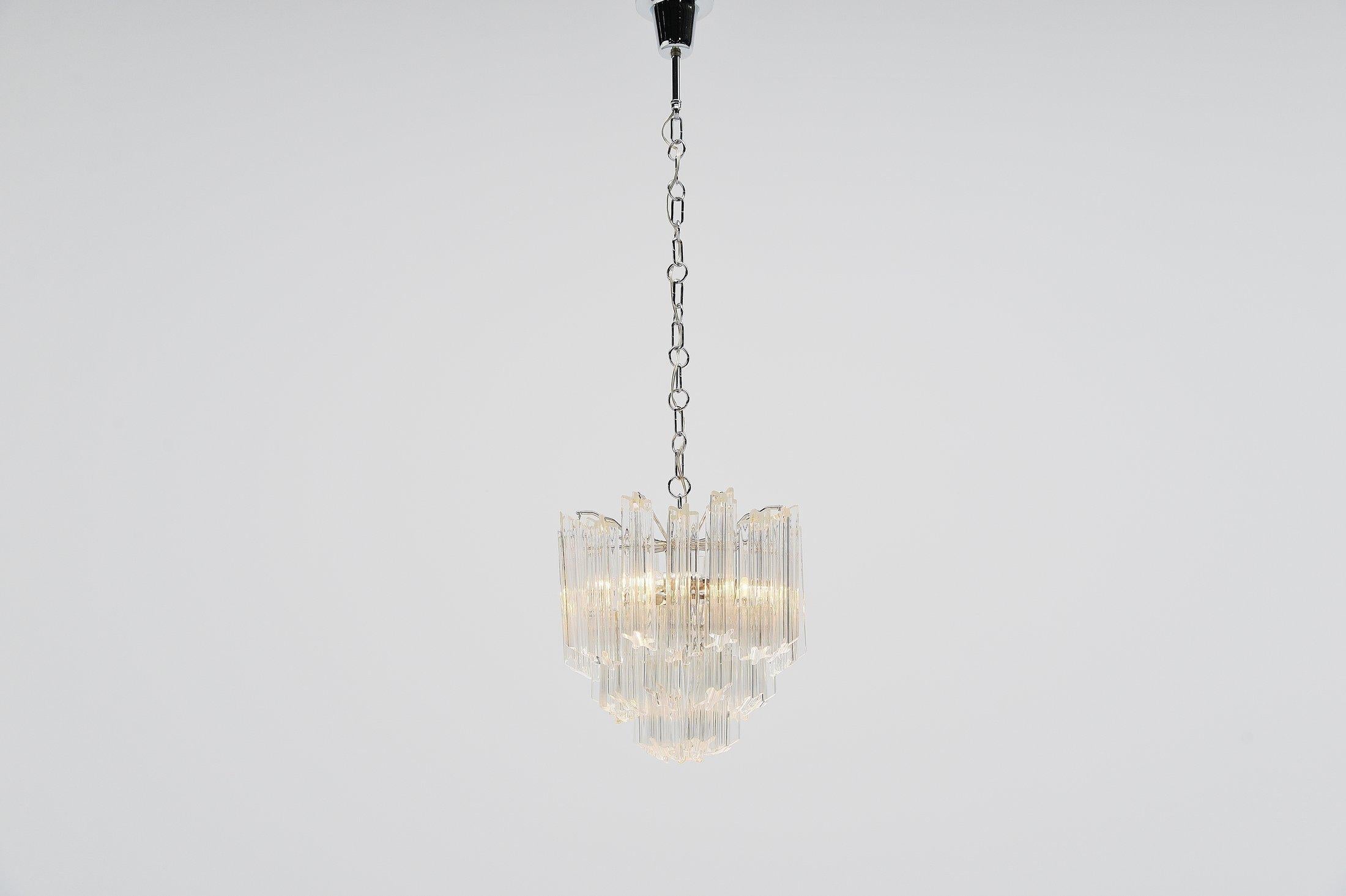 Nice and decorative chandelier designed by Paolo Venini, manufactured by Venini in Murano, Italy 1960. Chrome-plated structure with 32 clear glass pegs. Chandelier is in good and complete condition, gives great light when lit. The lamp uses 3x E14