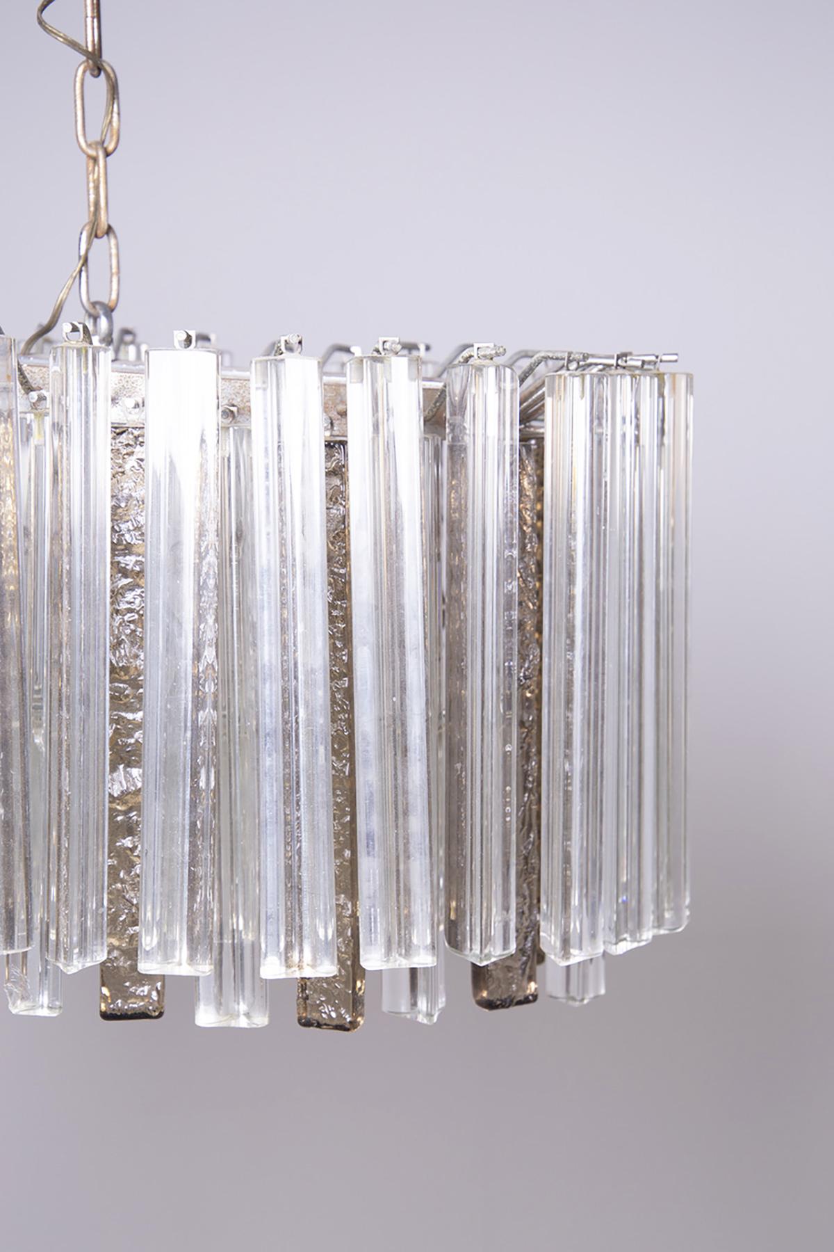 Beautiful chandelier made by Venini, steel structure and Murano glass stem in 1950.
The heavy chandelier is composed of small white and ivory Murano glass staves, respectively triangular-shaped white ones and rectangular-shaped ivory ones, also the