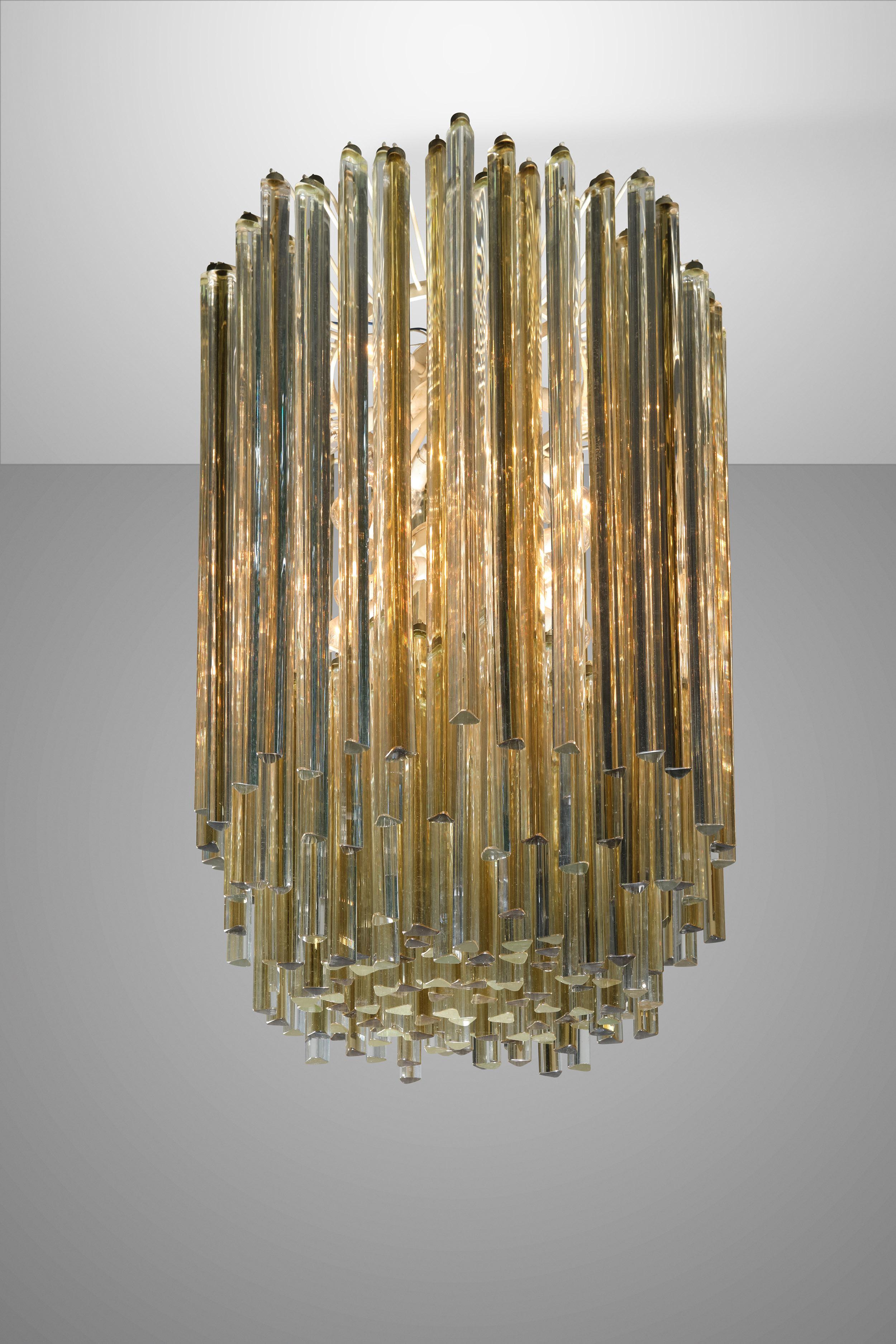 This amazing chandelier was produced by Venini in the 60s. Its metallic body mounts exceptionally refined Murano glass diffusers.
Thanks to its prismatic-shaped glasses, this item merges functionality with elegance. Marked Venini.