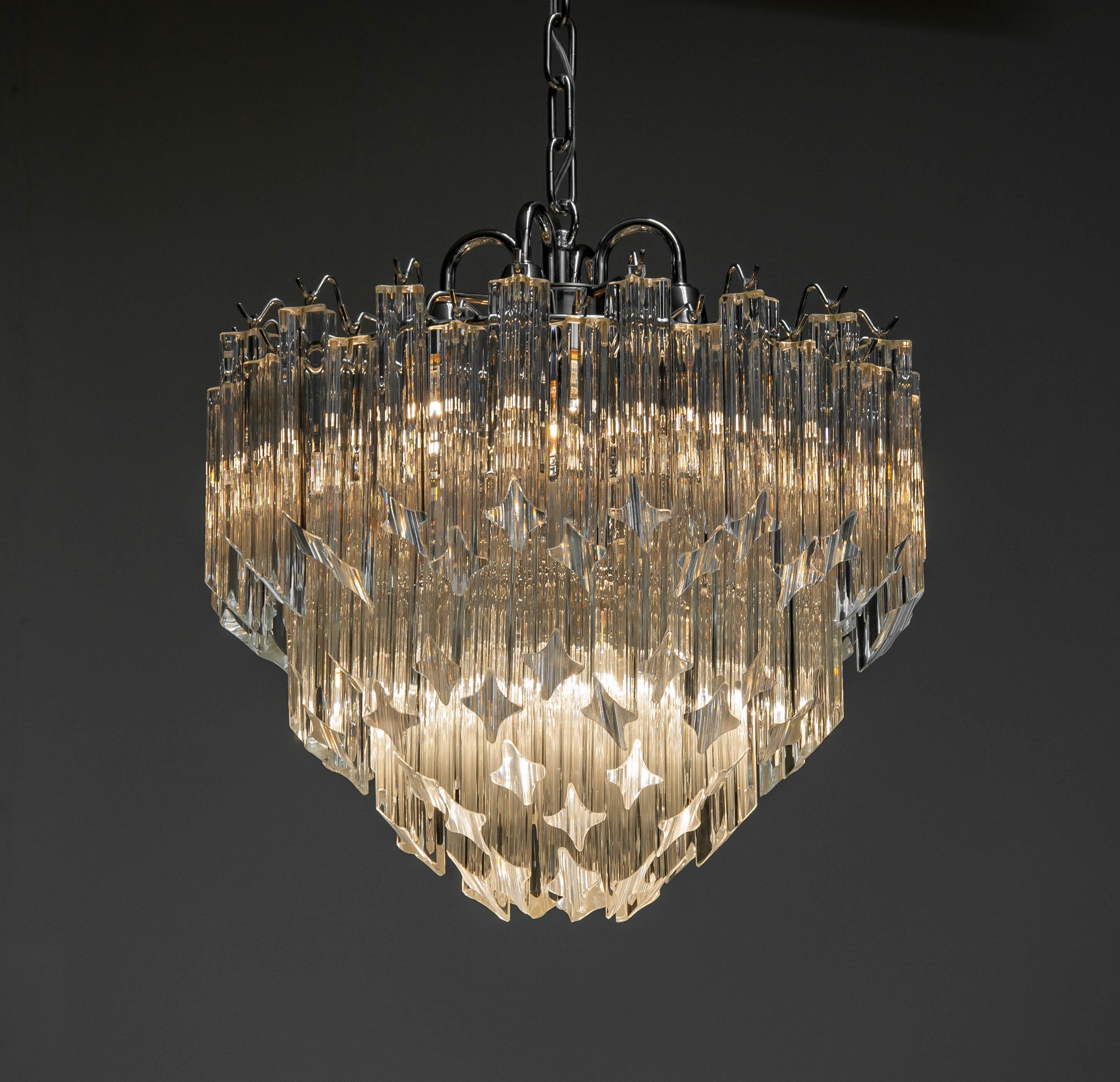 Beautiful chrome tiered chandelier attributed to Venini. The chandelier is filled with 91 clear Triedri Murano crystals and allover in original condition.
The chandelier has a diameter of 45cm / 17.7 Inches and height also 45cm / 17.7 inches.
The
