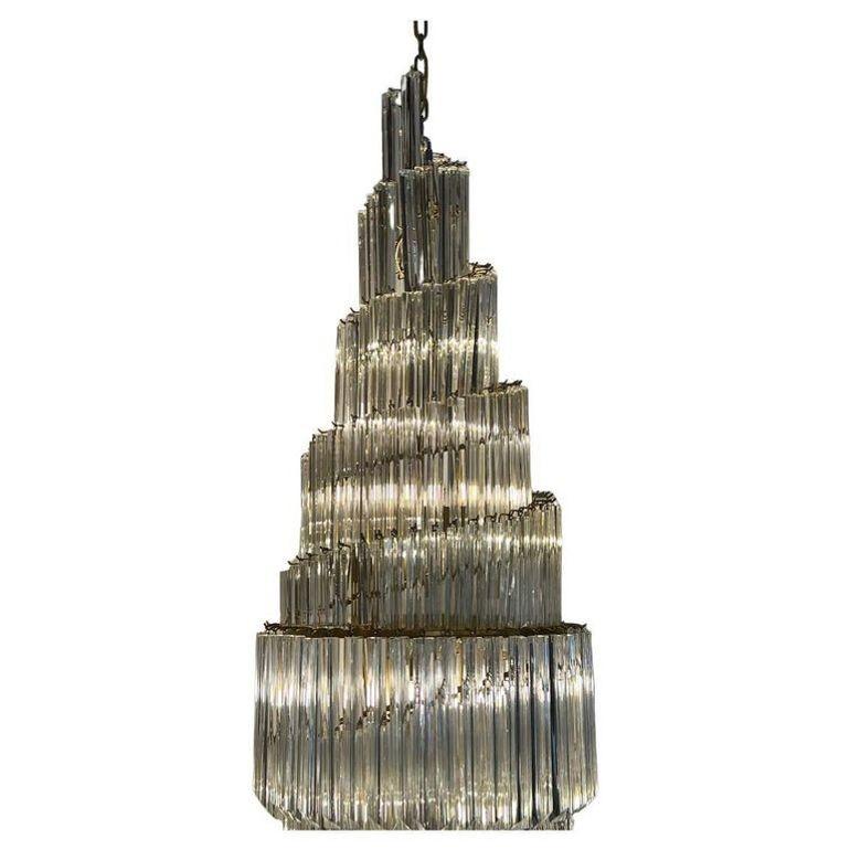 A breathtaking oversized double-tier Venini chandelier from 1970s Italy, featuring a mesmerizing swirling designadorned with Triedri glass prisms. This stunning piece is illuminated by 14 lights, which radiate through the expertly cut glass, casting
